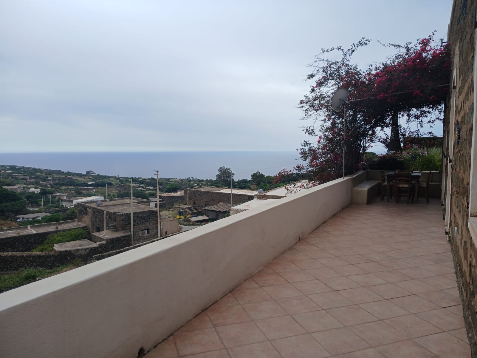 Panoramic terrace of dammuso in Rekhale with flowering pergola and sea view