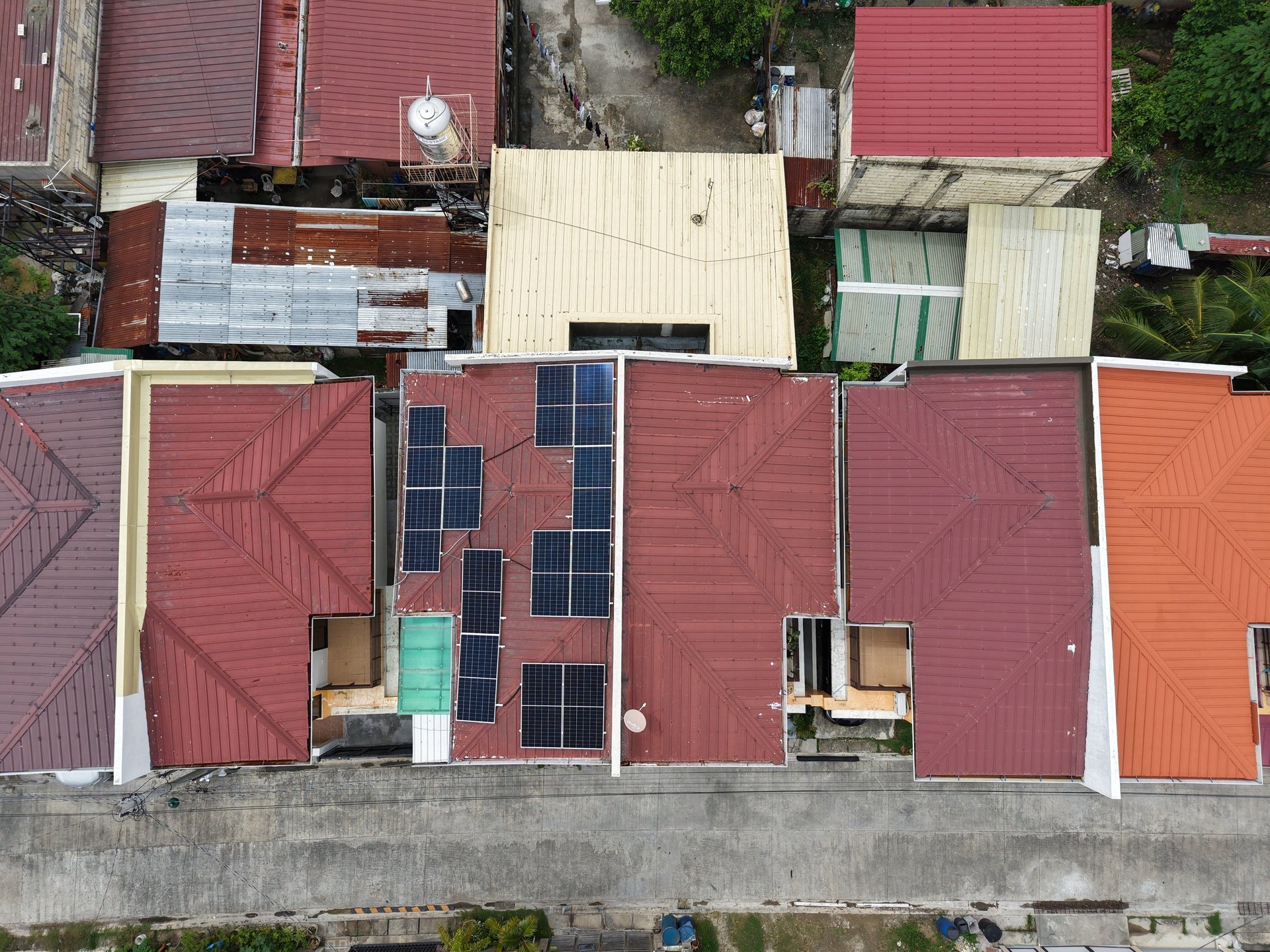 Aerial view of residential rooftops with installed solar panels for sustainable home energy.