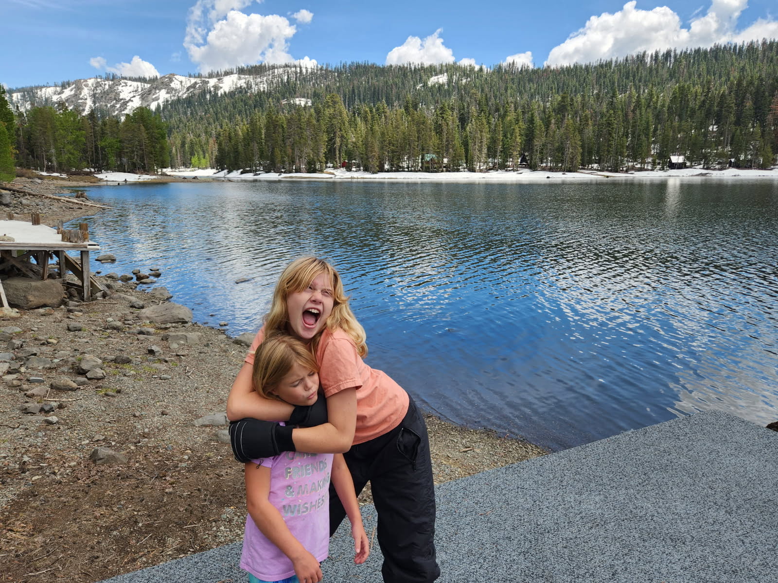 Cecelia and Mary Grace hugging by a lake