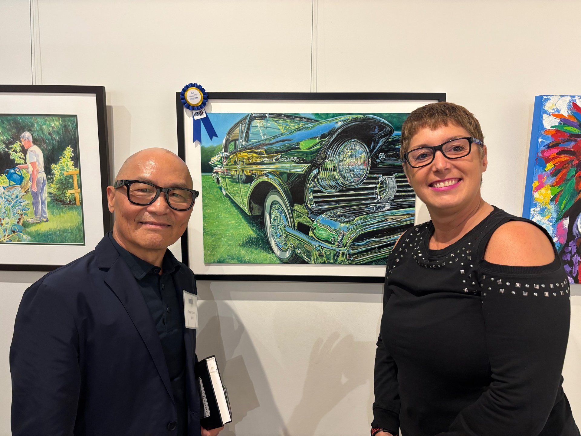 Photo of Sue and Peter Cheung (Judge) displaying 2nd place win painting