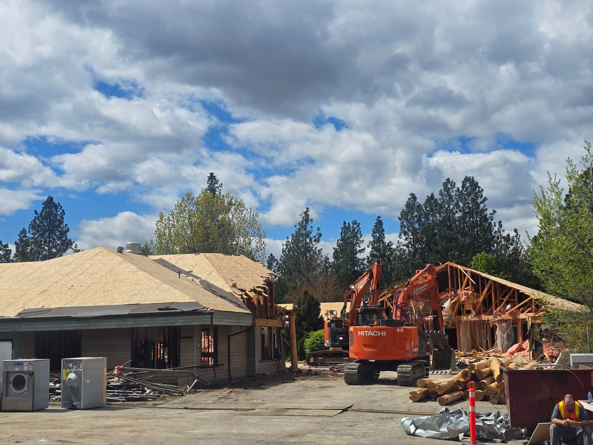 Two excavators demolishing a large structure