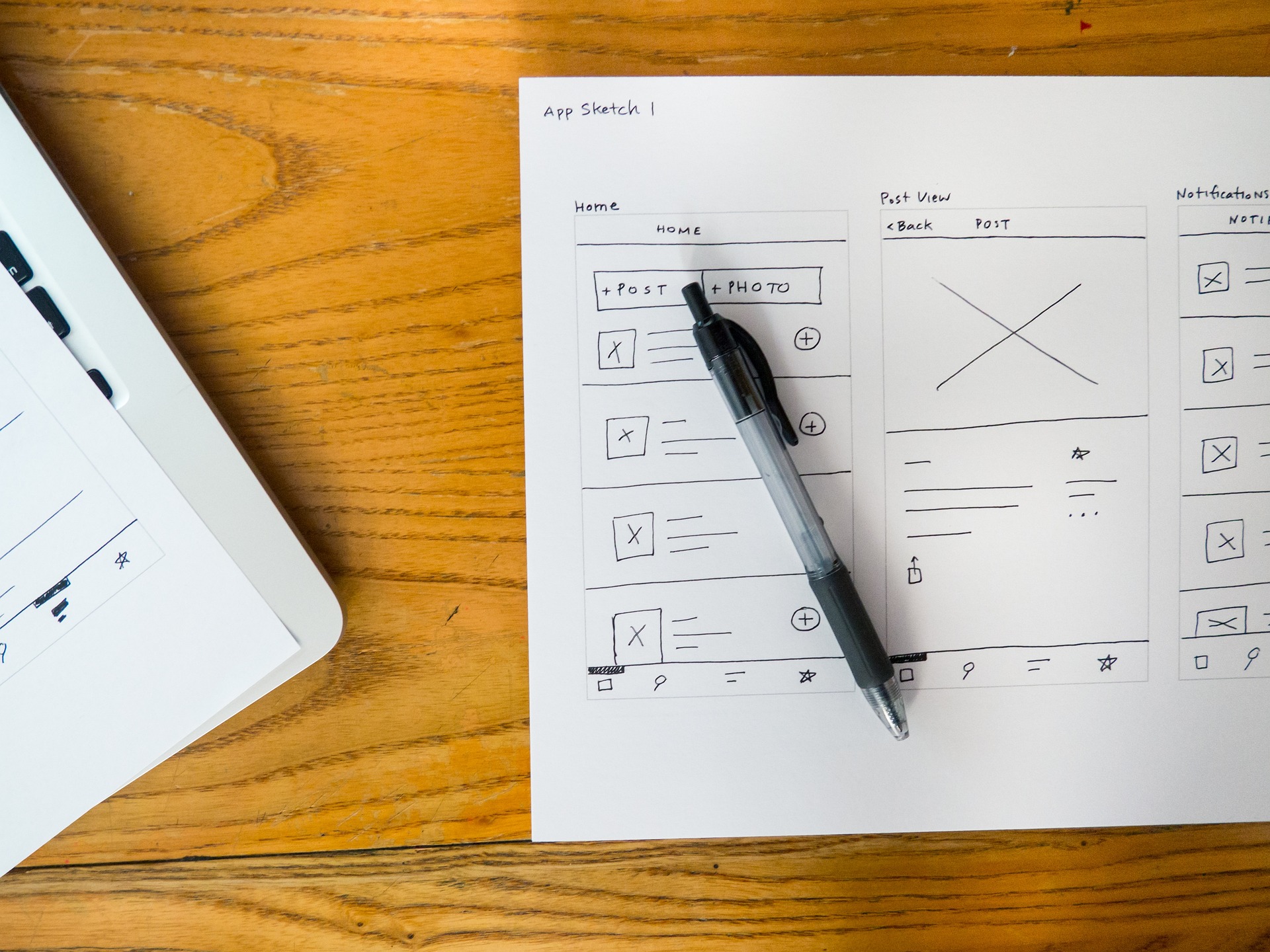 wireframe outline of customer experience design on a piece of paper and a pen