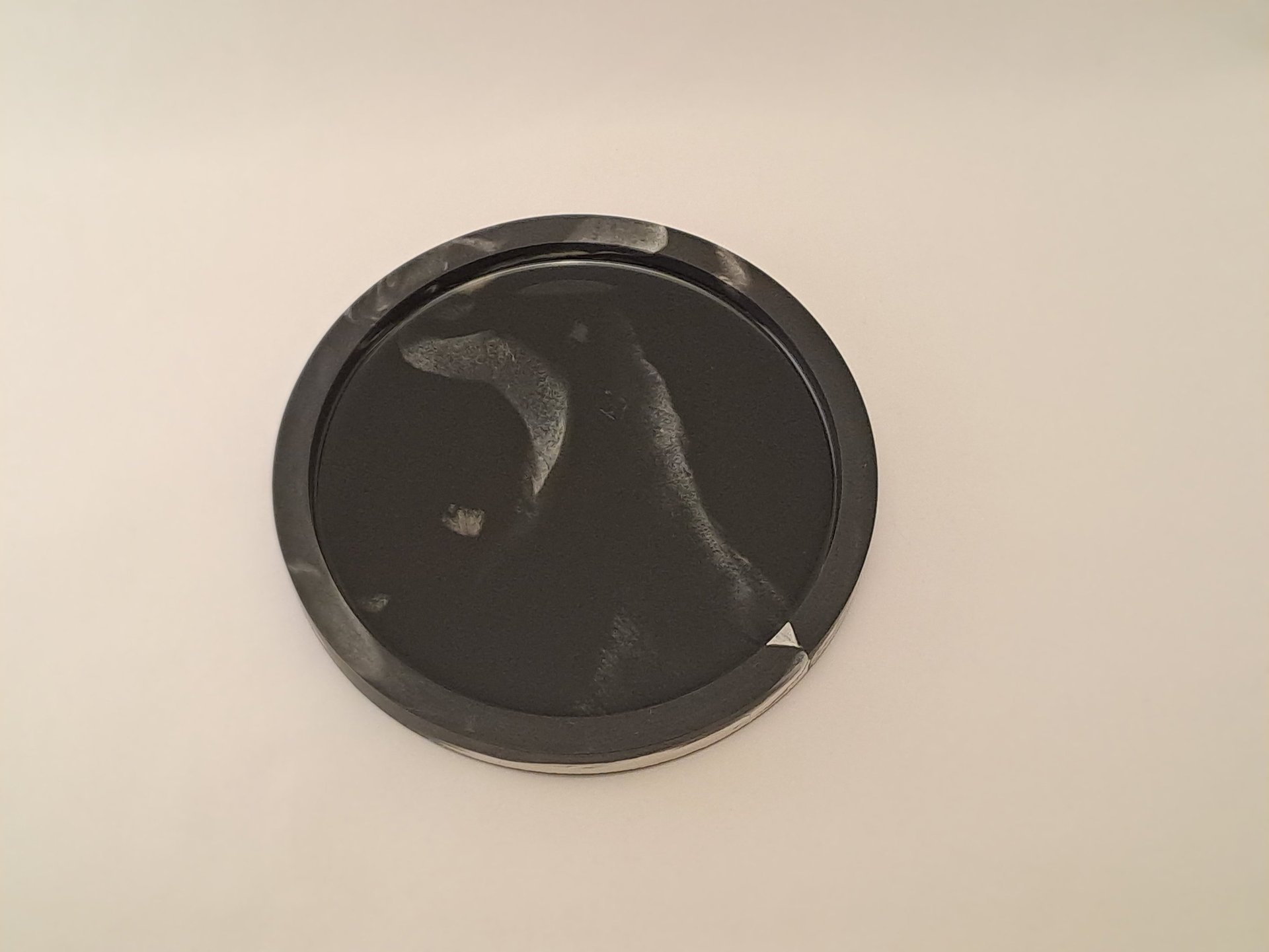 Handcrafted circular dark tray with black resin interior featuring misty white marbled swirls