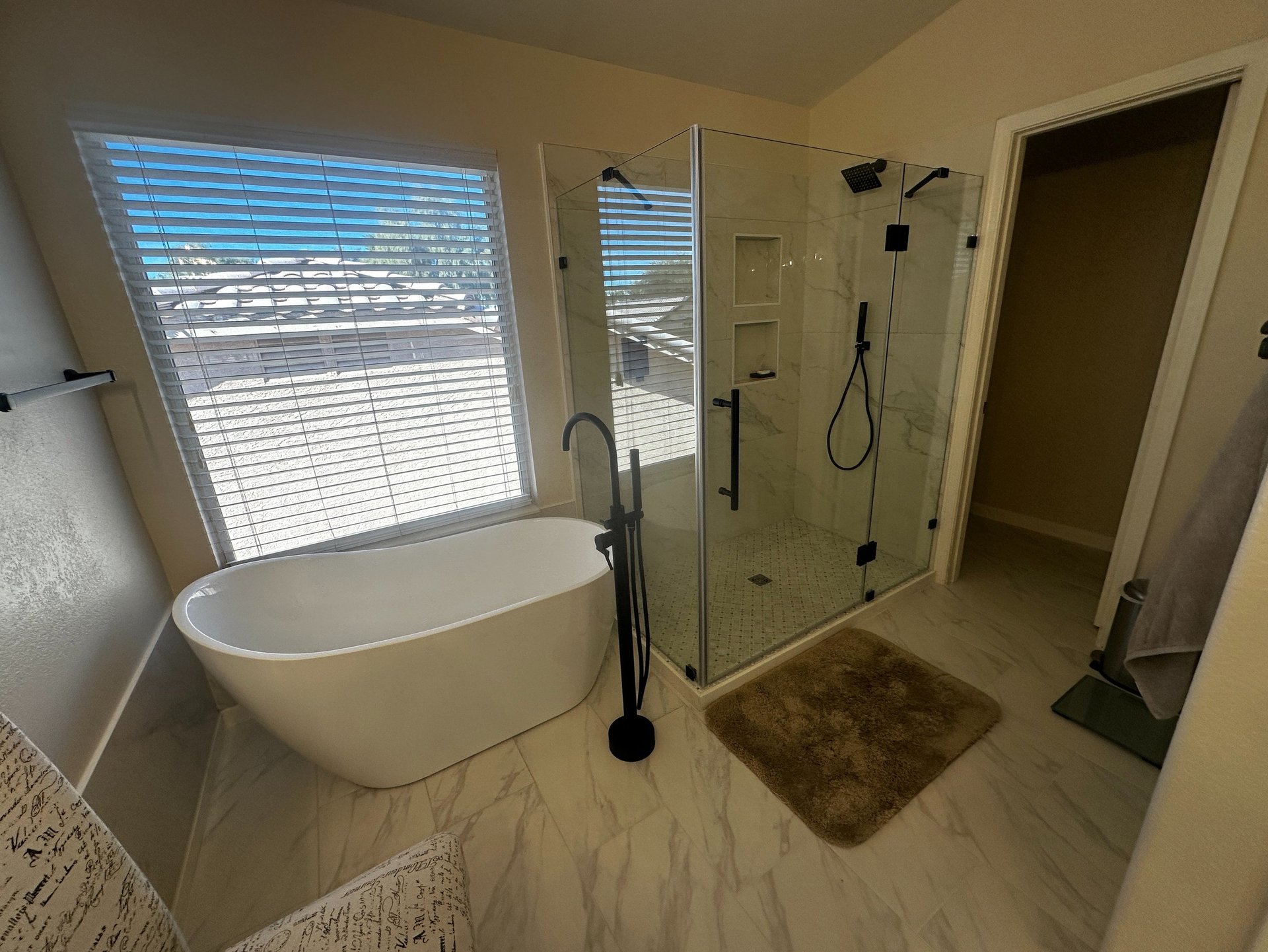 a remodeled bathroom with a stand alone tub and a walk in shower