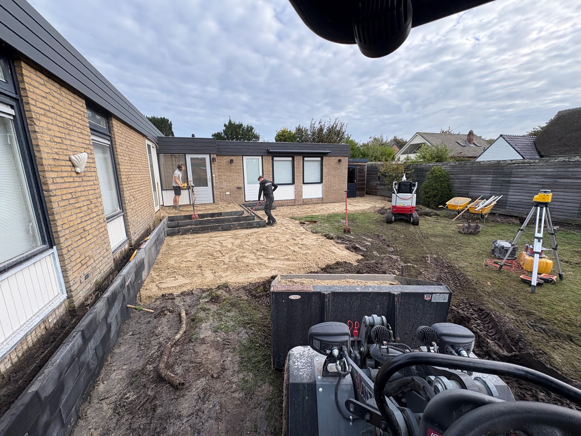 Betsema Bestrating bezig met grondwerk in een tuin.