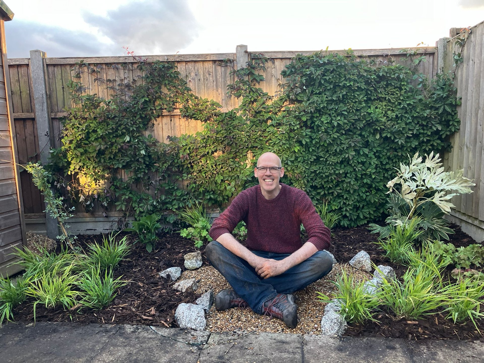 Garden designer Conor O'Donovan sitting in a shady corner garden in London