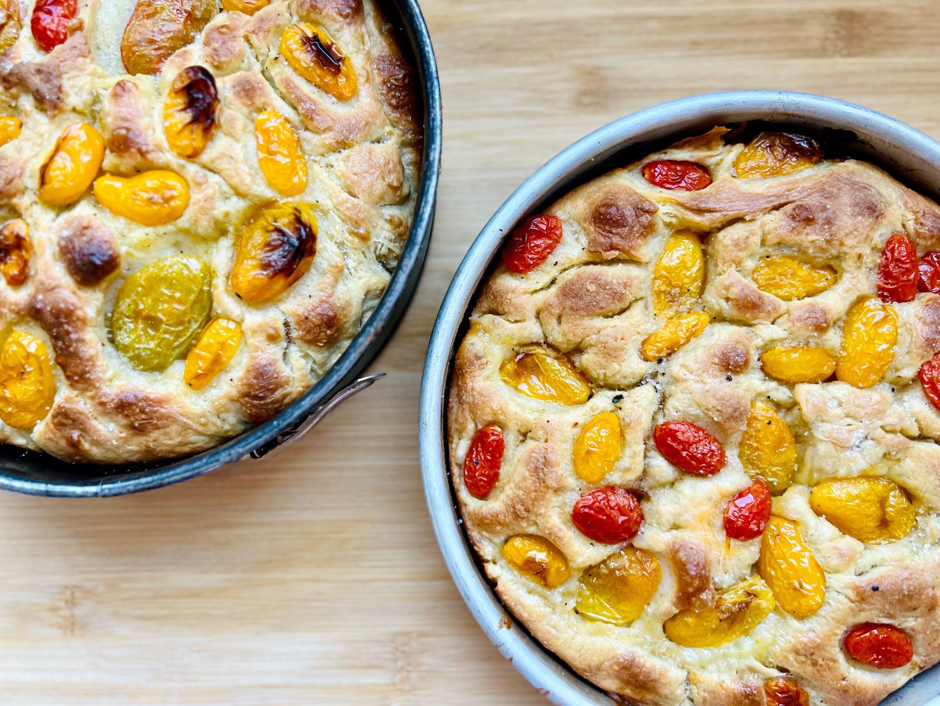 focaccia baked and presented on the mold with market tomatoes