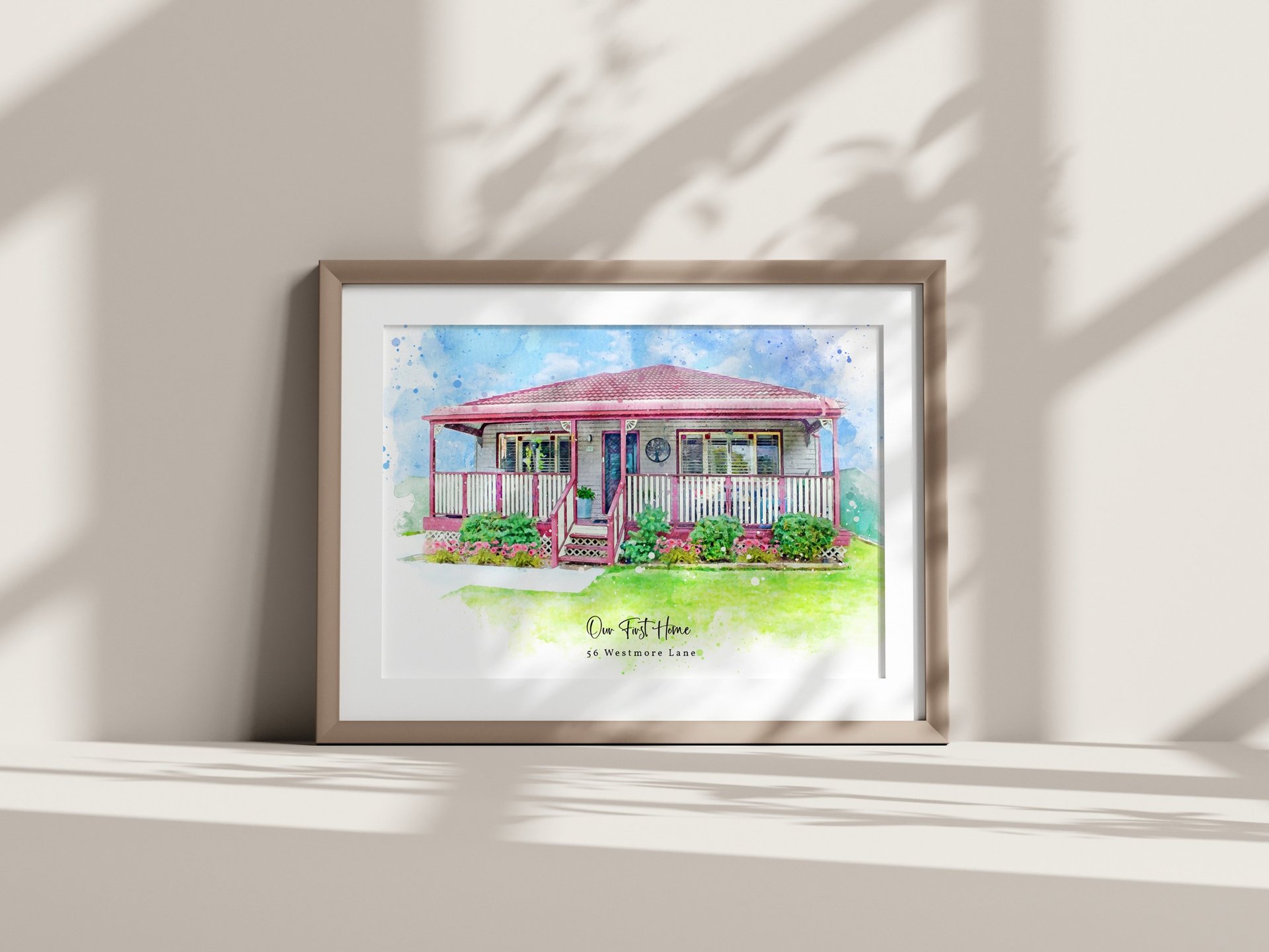 Framed watercolour painting of a house leaning against the wall with shadows
