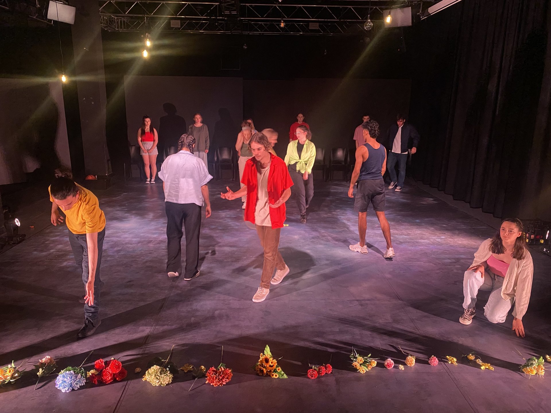 a group of people standing around a circle of flowers