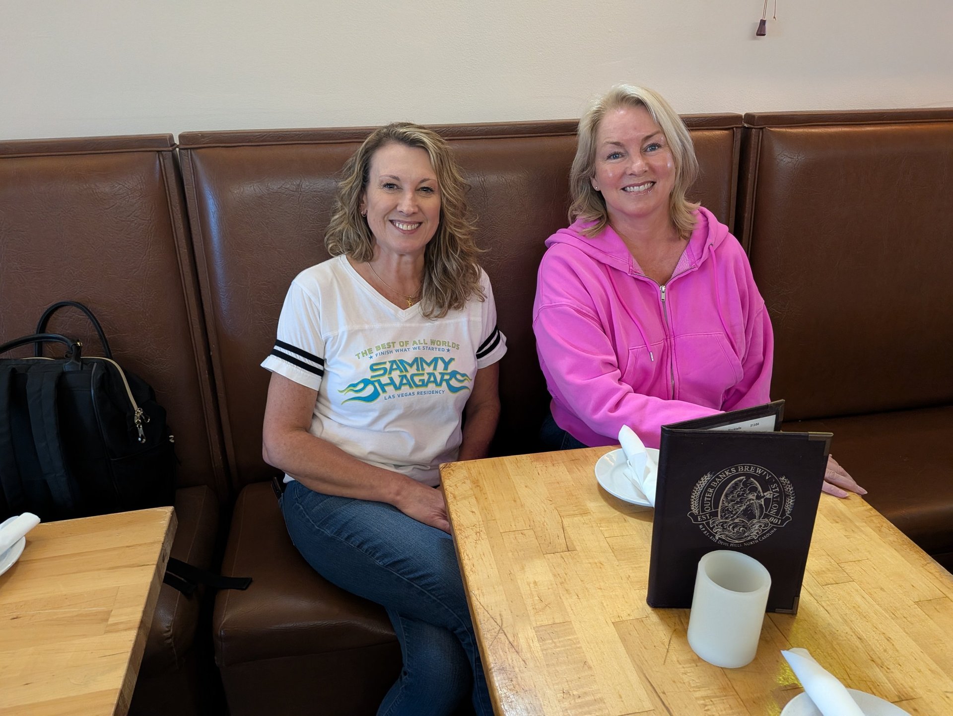 women seated in a booth at obx brewing station