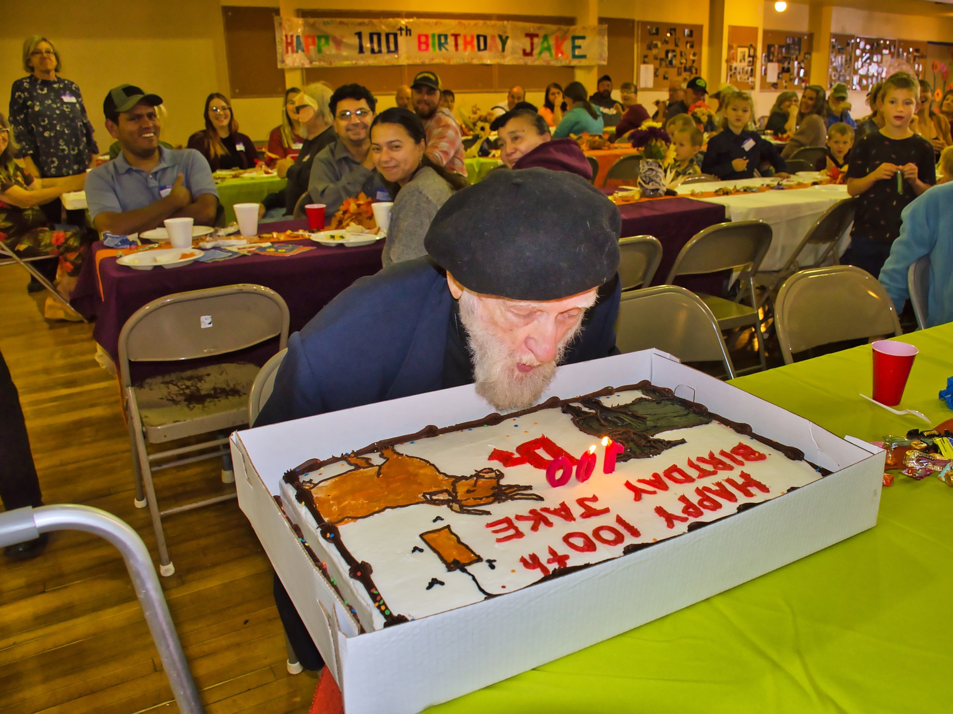 a man blowing out a candle on a cake for his birthday