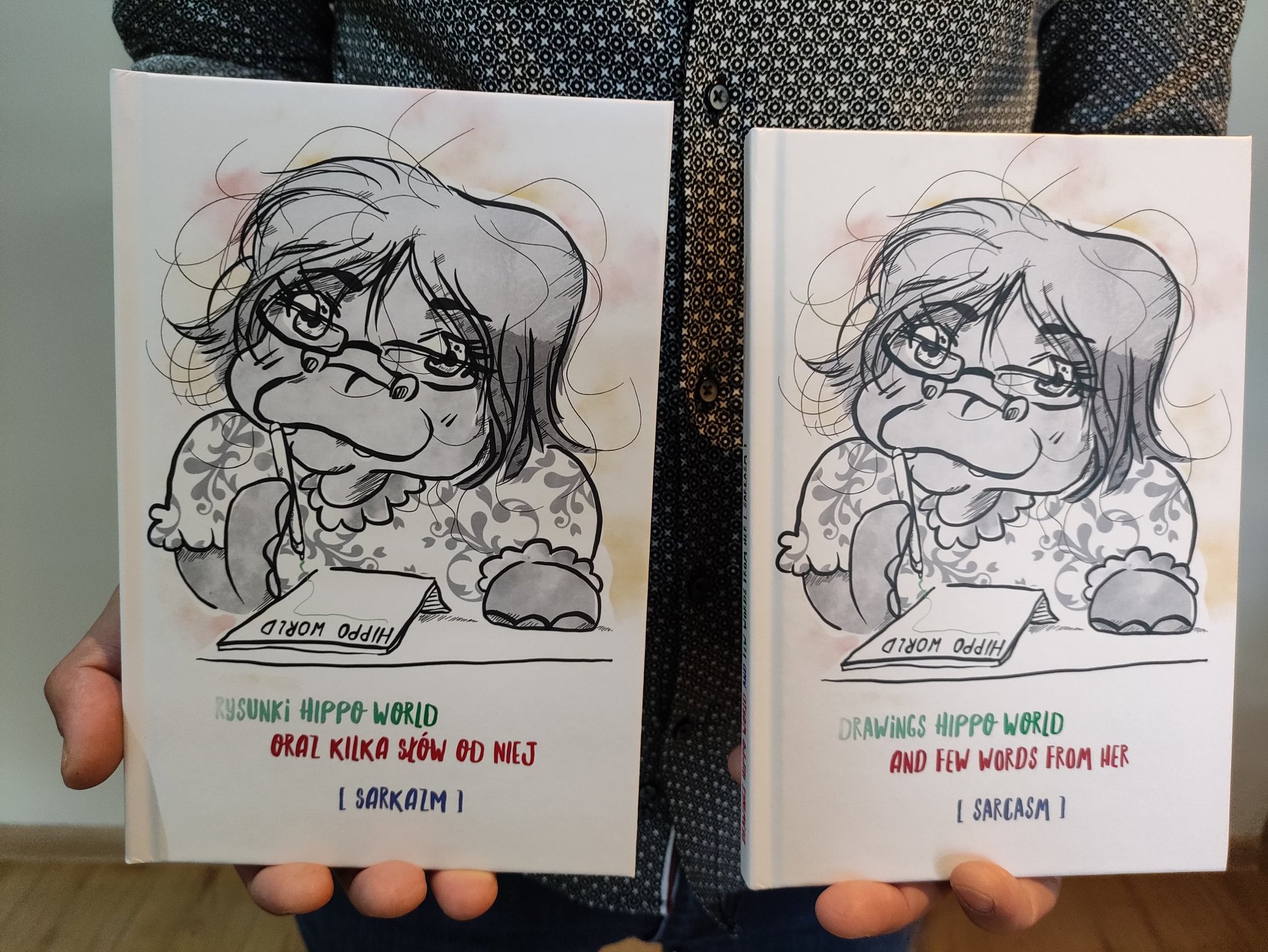 a person holding two cards with a drawing of a girl