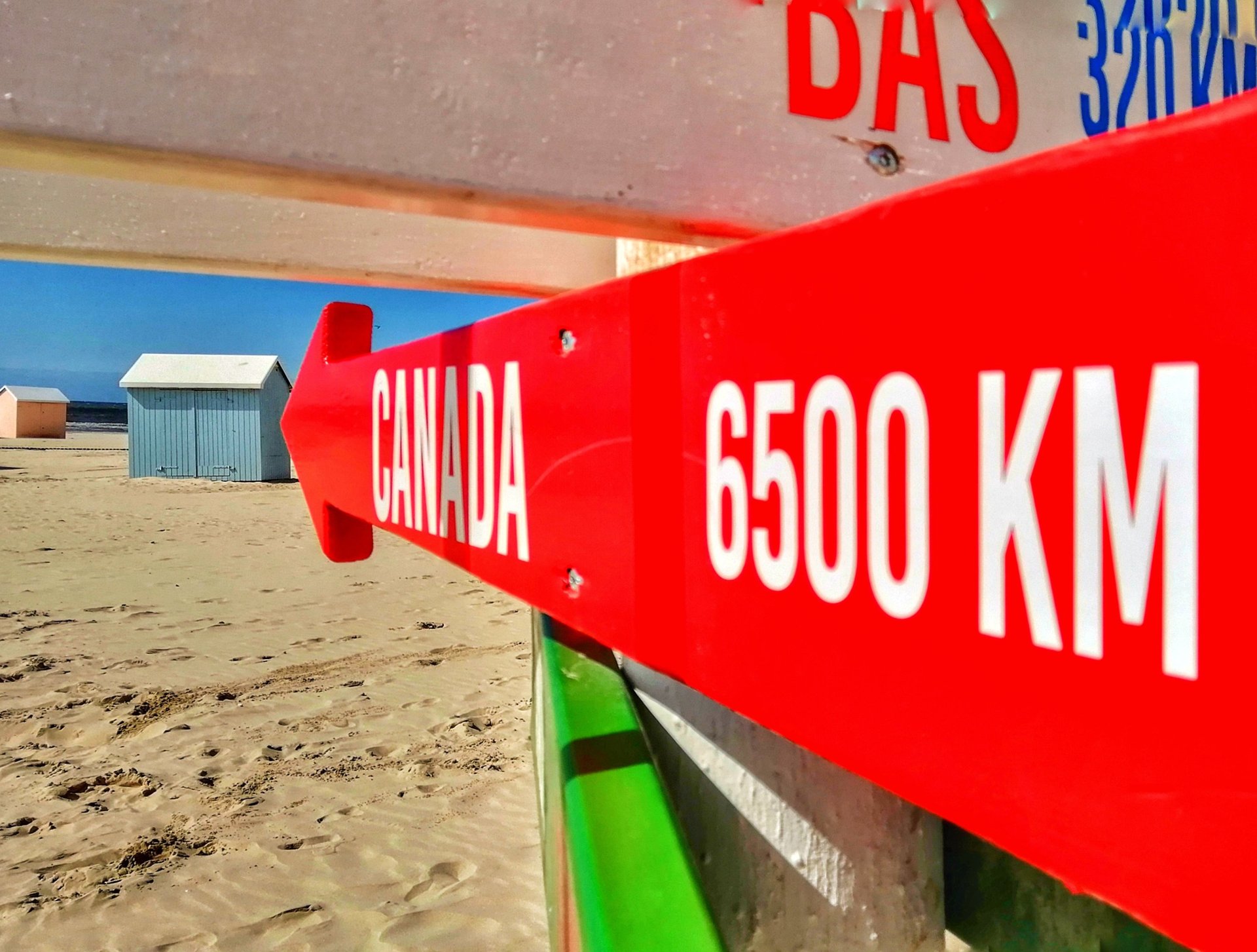 un panneau rouge et blanc qui indique ma cabane au canada sur la plage de Berck