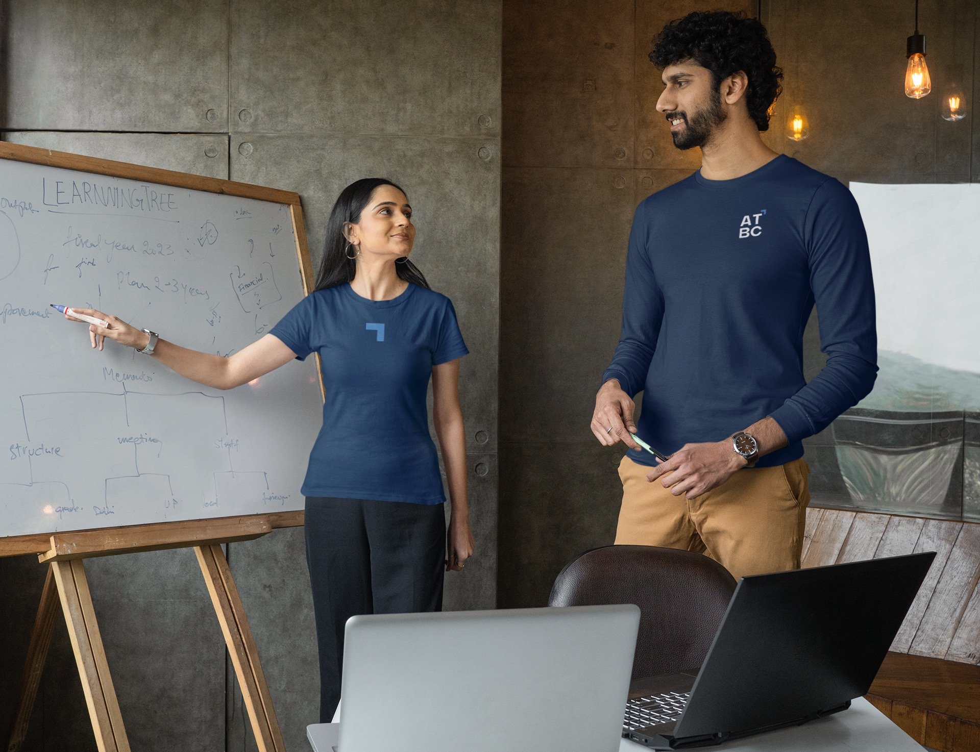 a man and woman standing in front of a white board board