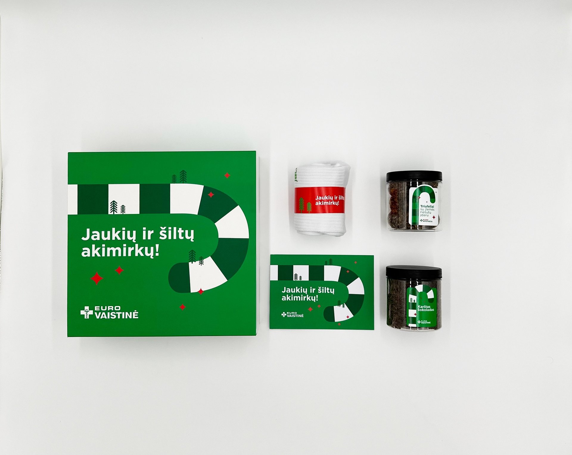 Eurovaistinė holiday gift set with green gift box, cozy socks, and two jars of herbal tea.