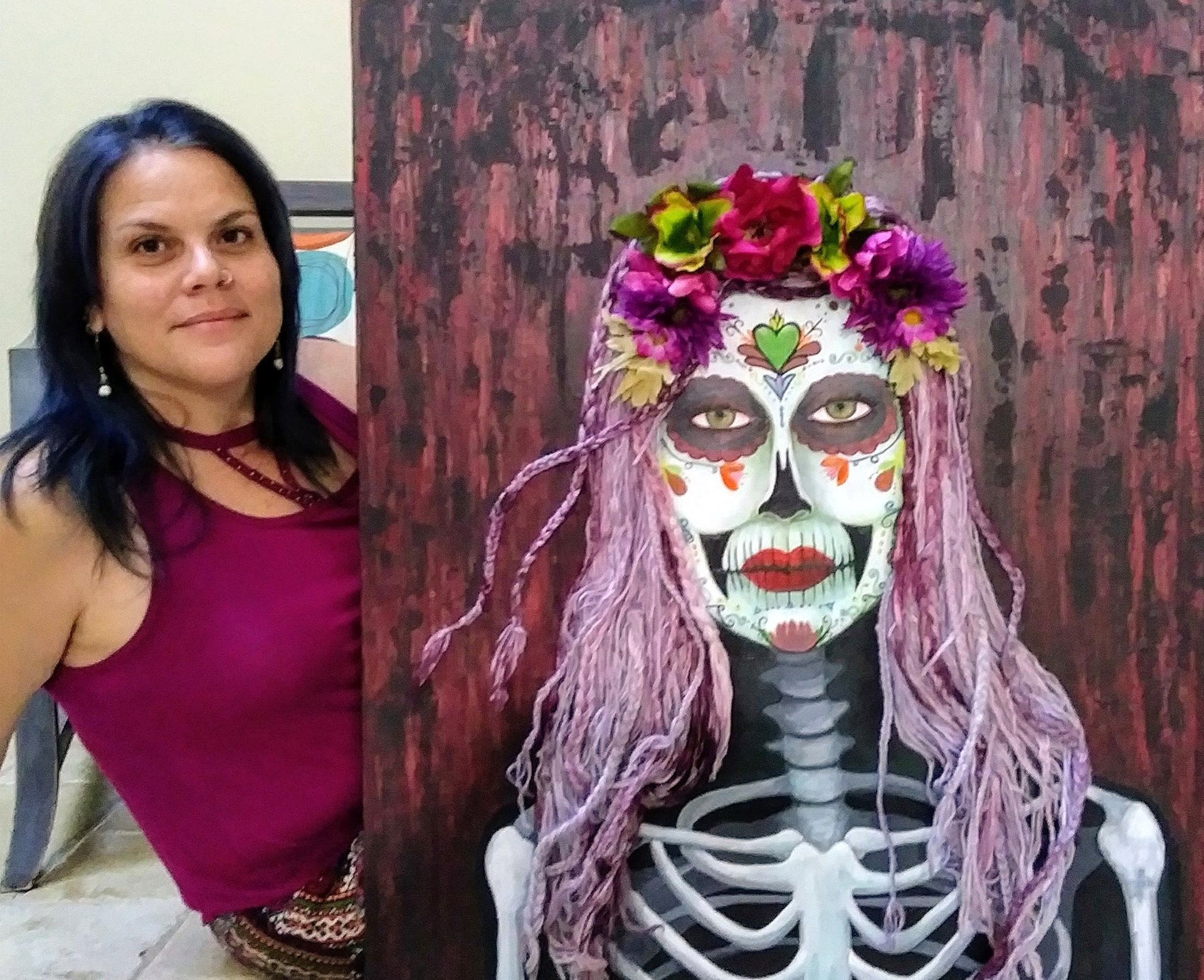 a woman in a red dress and a skeleton with a flower headdress