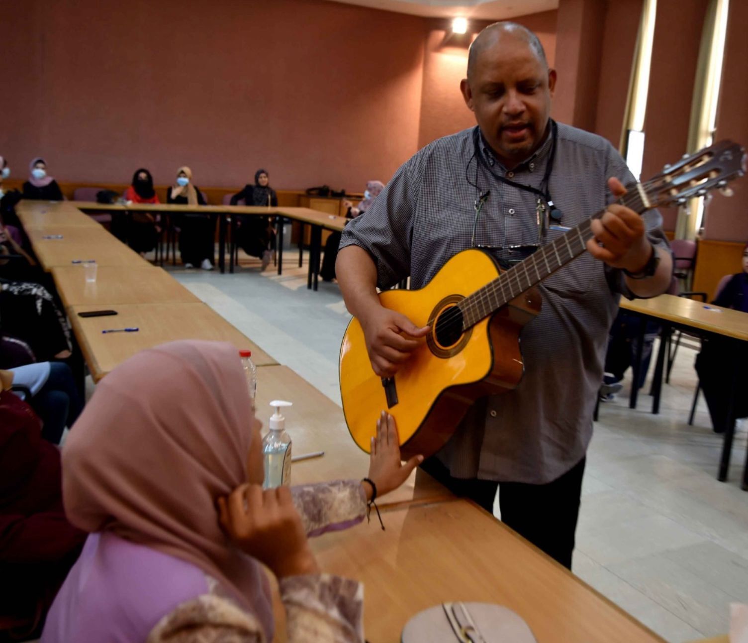 Former UN official Bruno Donat playing guitar with deaf women in Gaza, Palestine