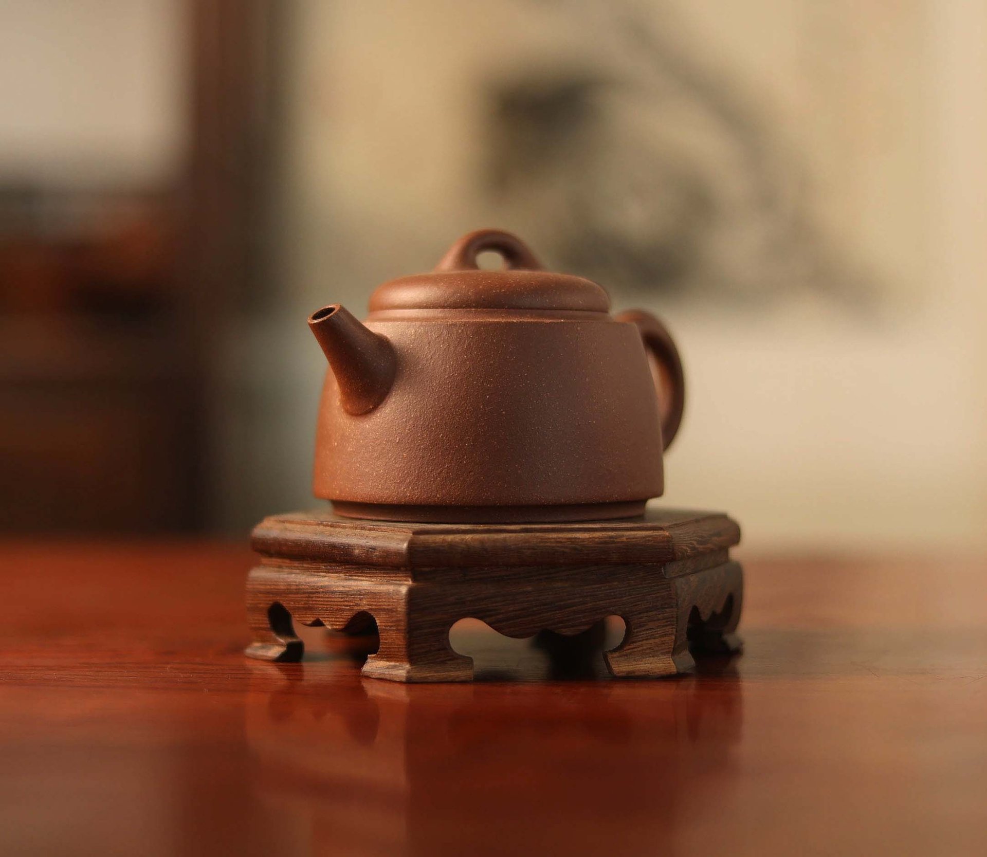 Brown teapot placed on a wooden stand