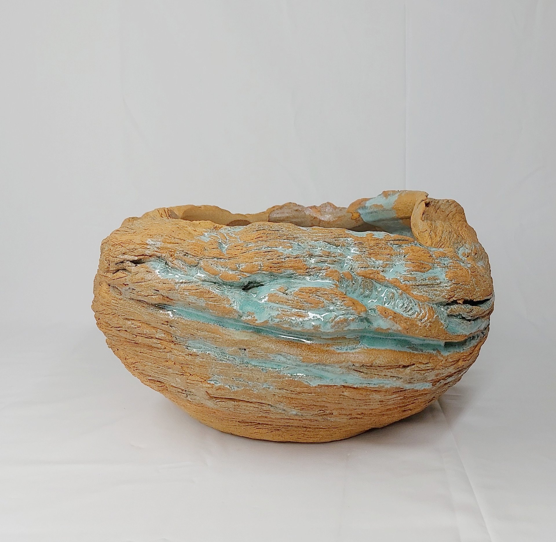 Estelle Del oeuvre artistique d'un pot en grès roux texturé émaillé en vert, inspirée des fa:laises