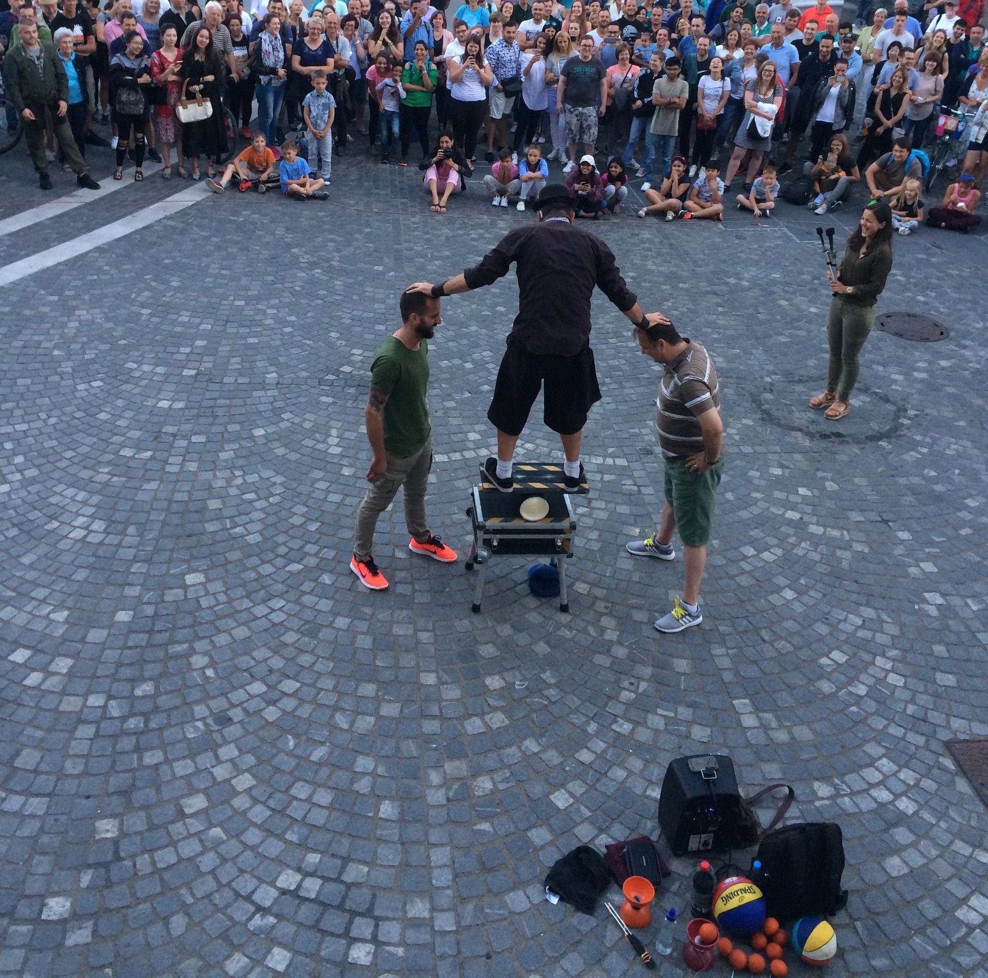a man performing a street show balancing on a rola bola