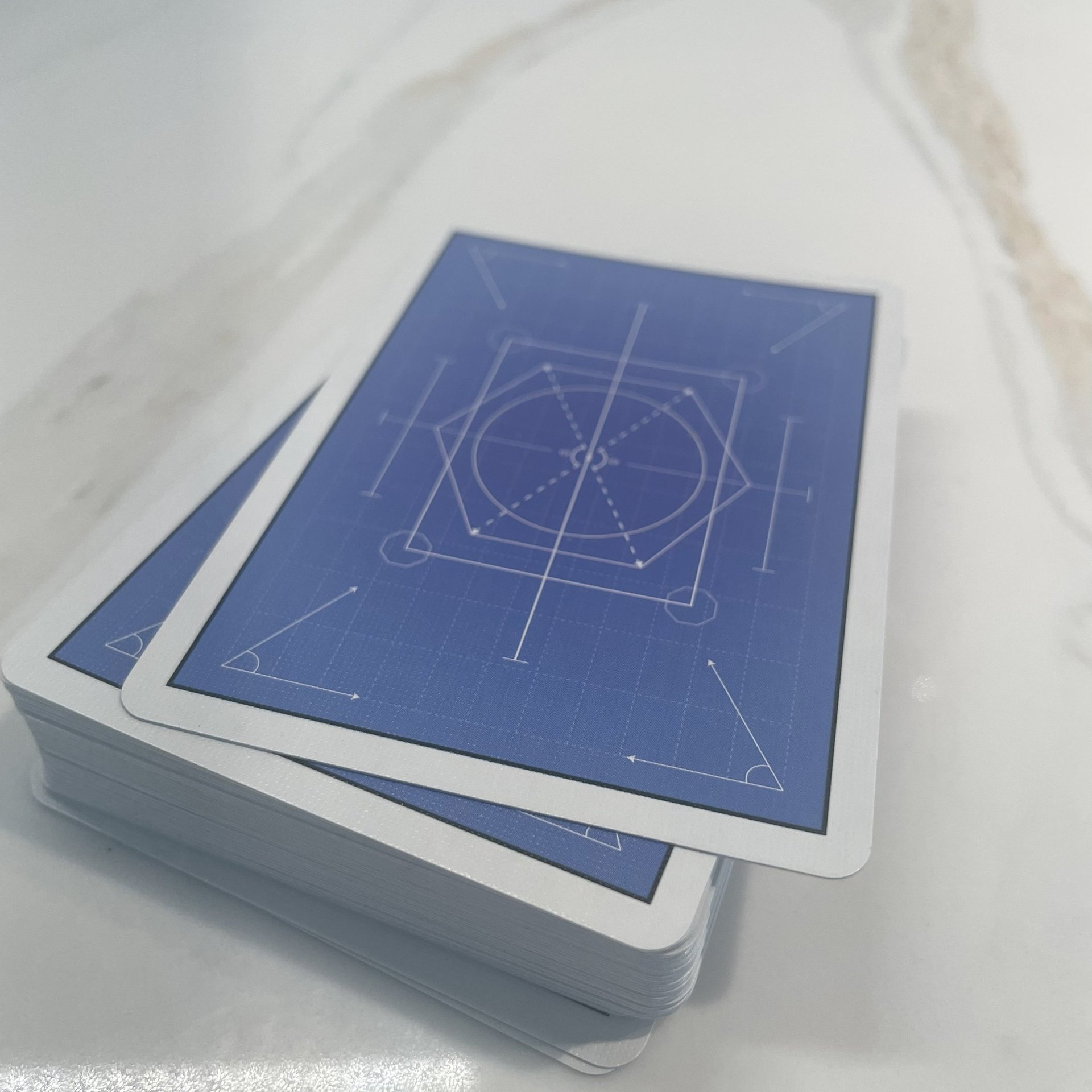 Back side view of stack of playing cards. Shows engineering and mathematics themed abstract art