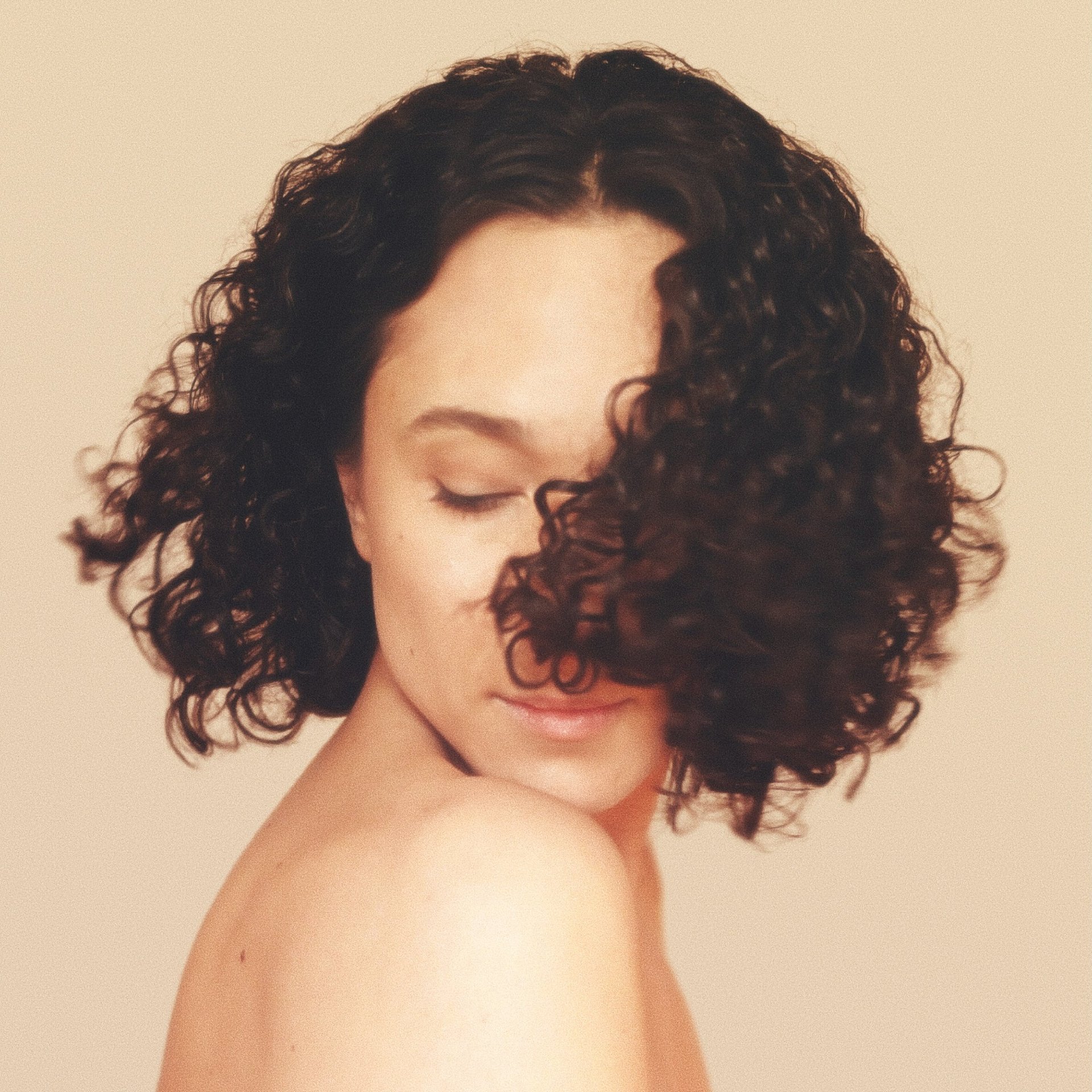 a woman with curly hair and a short haircut