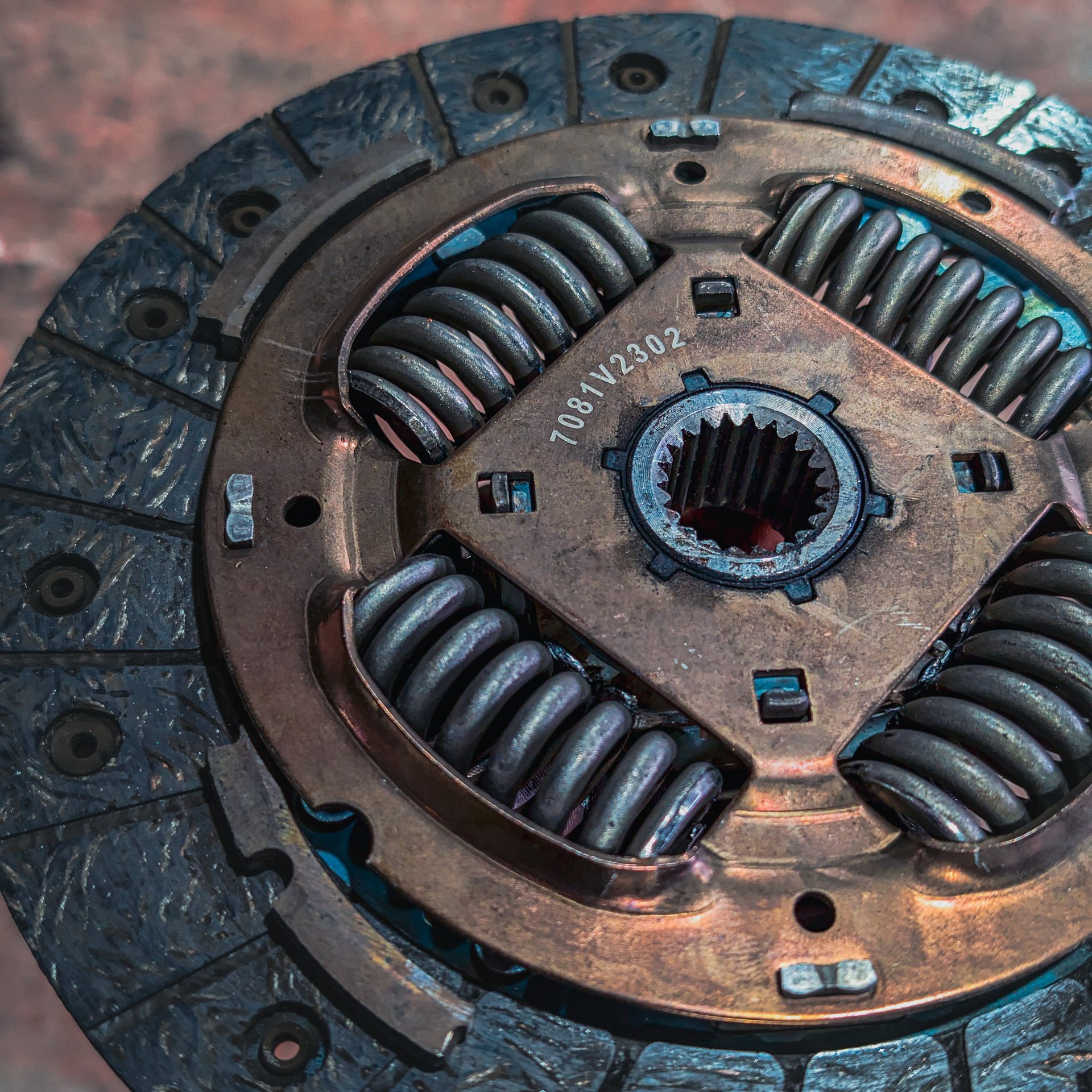Close-up of a heavy-duty car clutch plate showing the metal friction disc and damper springs.