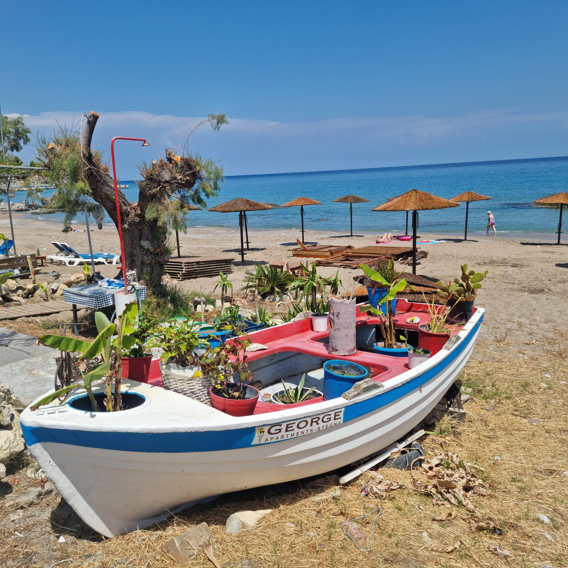 a boat sitting on the beach with umbrellas