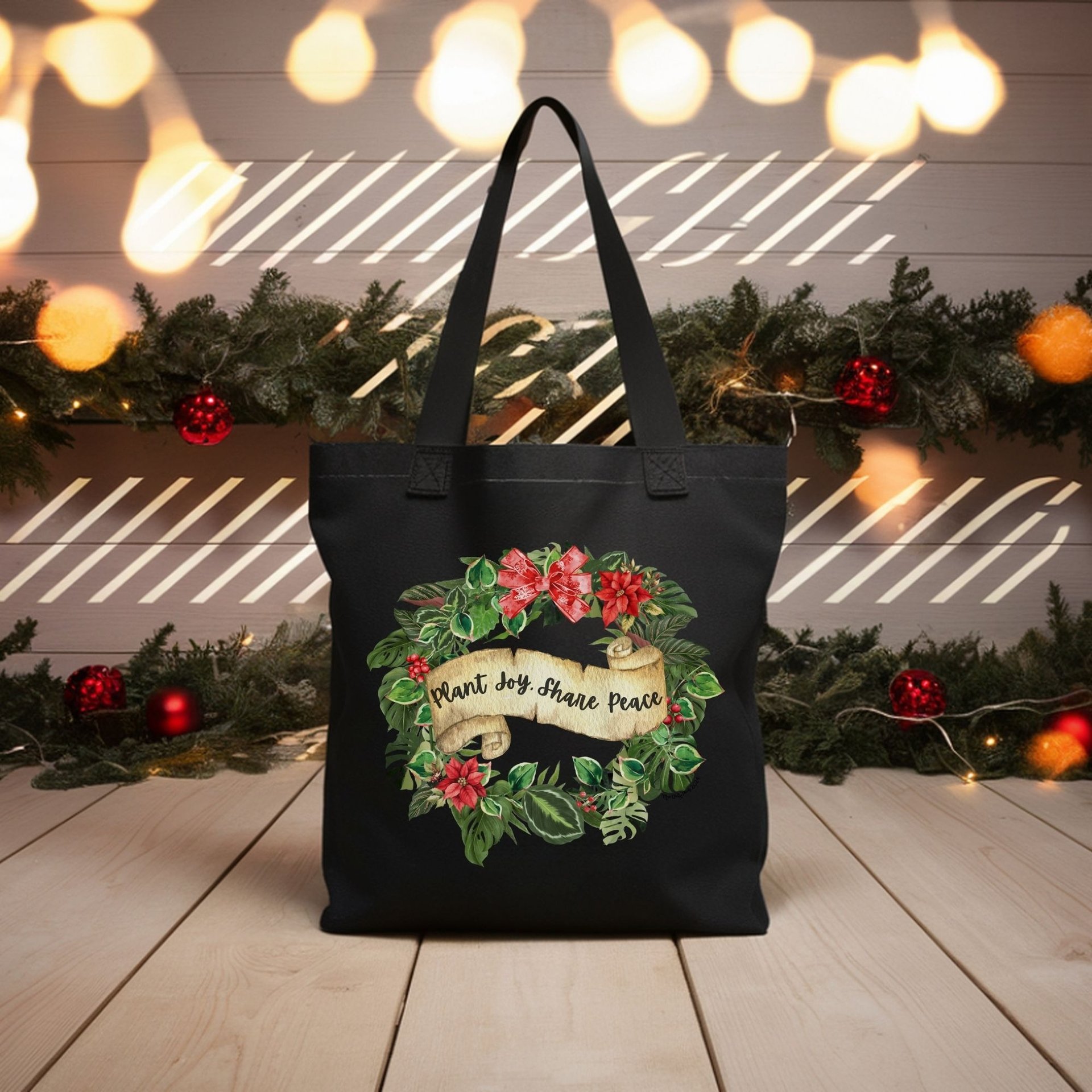 Black tote with poinsettia wreath and “Plant Joy. Share Peace” — botanical holiday bag by Miss Chatty Plants