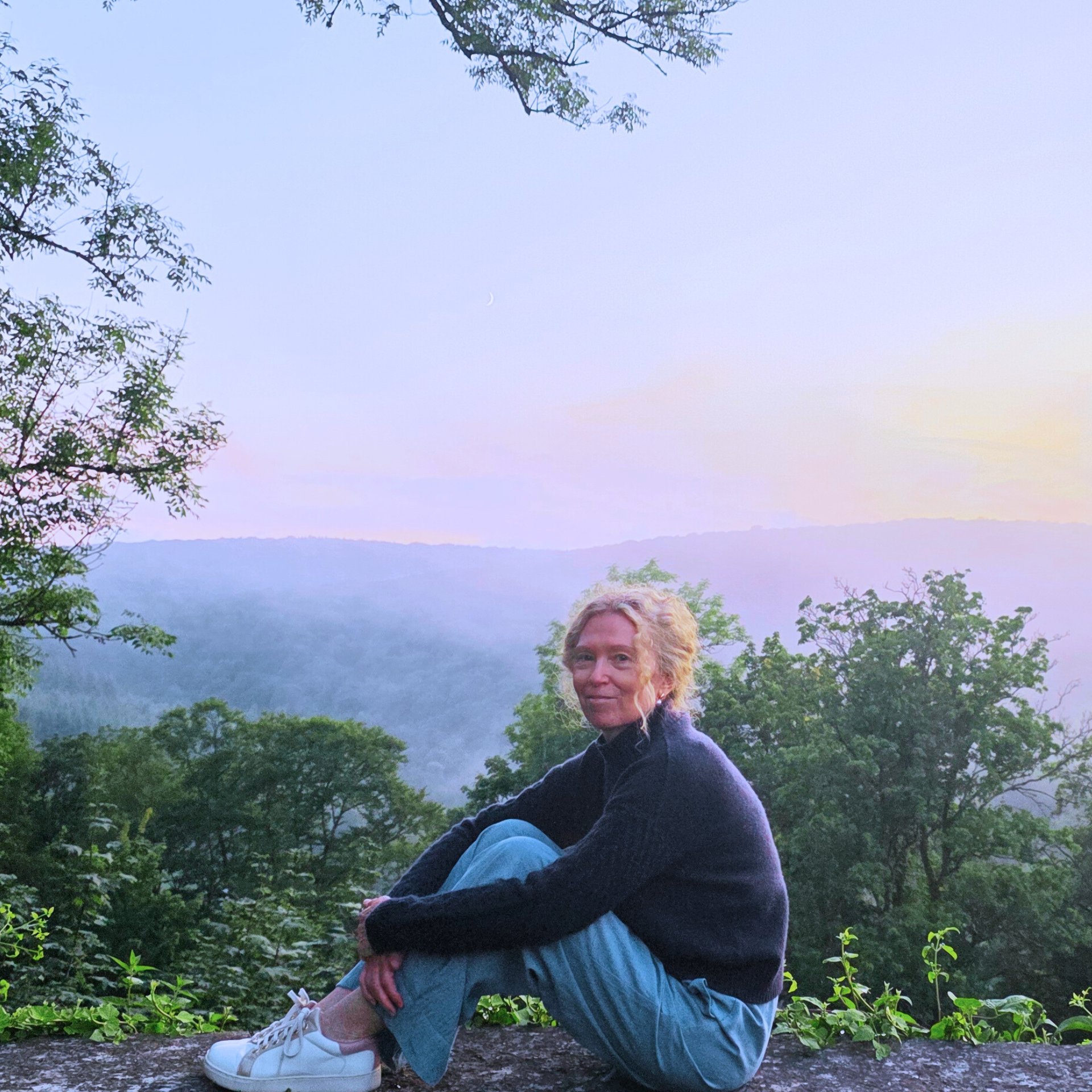Tanja Holvoet in een rustige natuuromgeving bij zonsondergang.