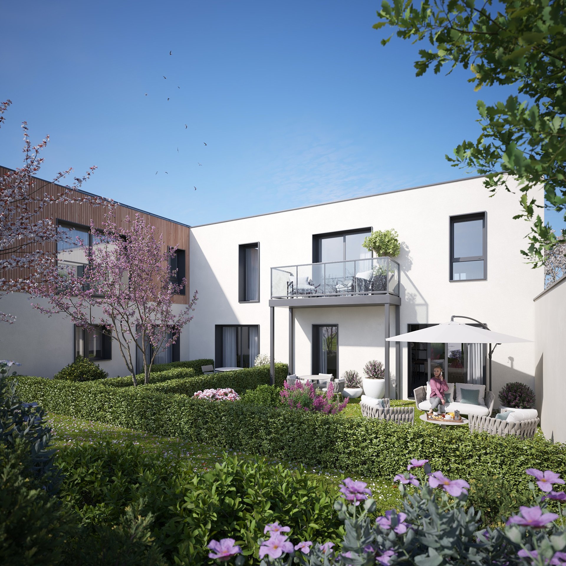 Vue des logements ouverts sur un jardin paysager dans la résidence Les Terrasses du Fort
