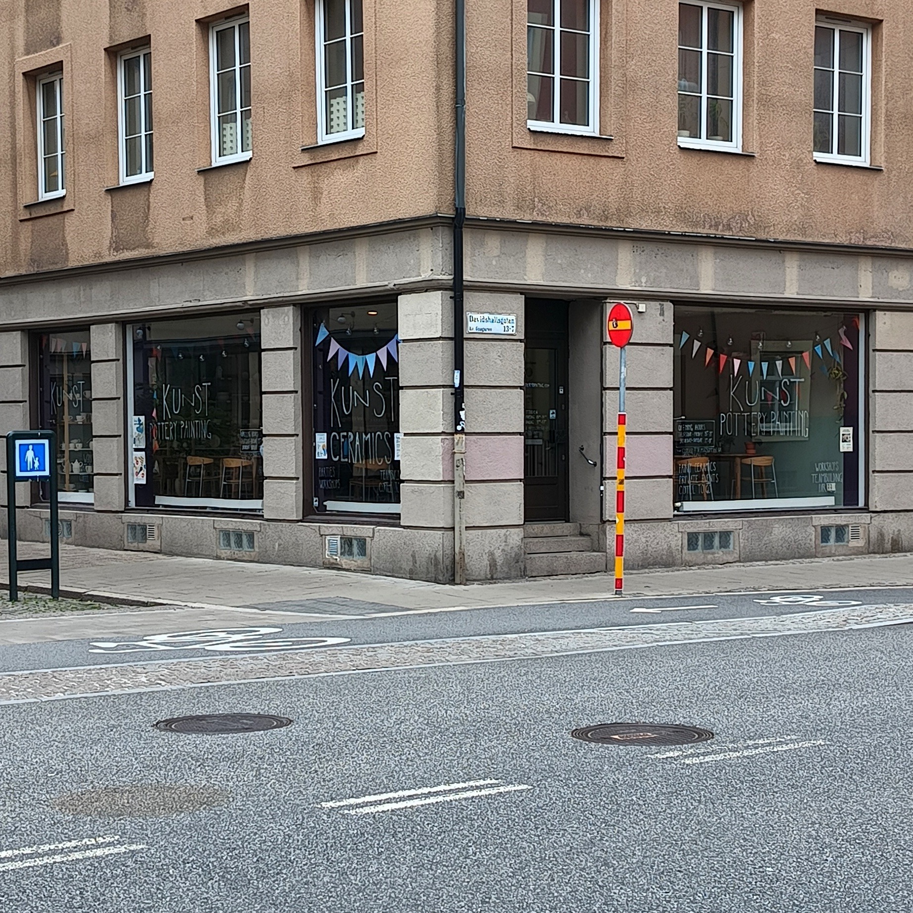 Pottery painting cafe storefront windows showing chairs and tables inside.