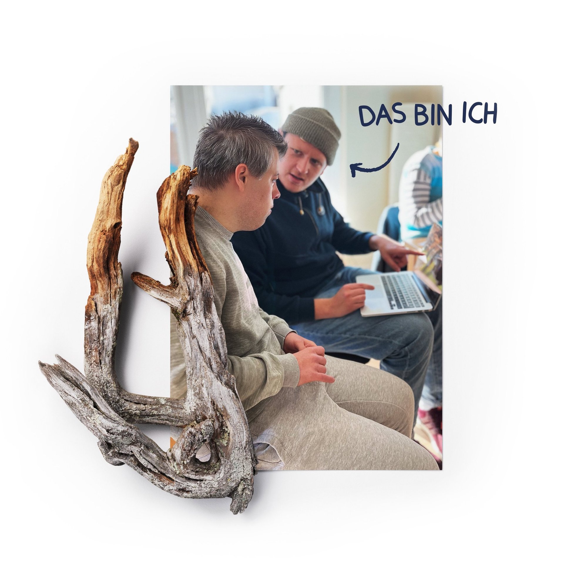 Mann mit Laptop erklärt einem jungen Mann mit Down-Syndrom etwas