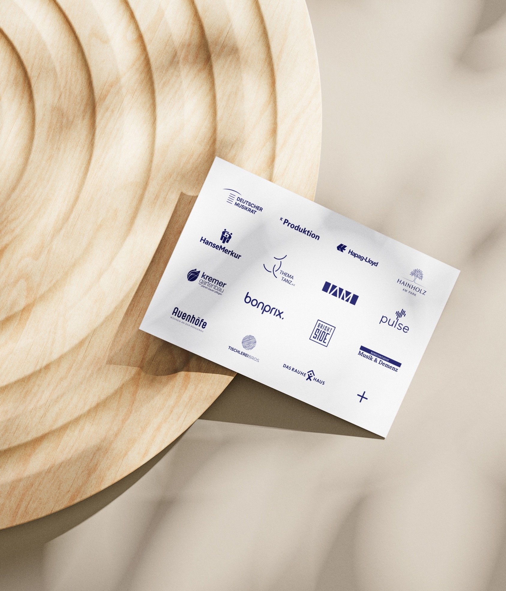 Flyer mit Logos von Kooperationspartnern liegt auf rundem Holztisch