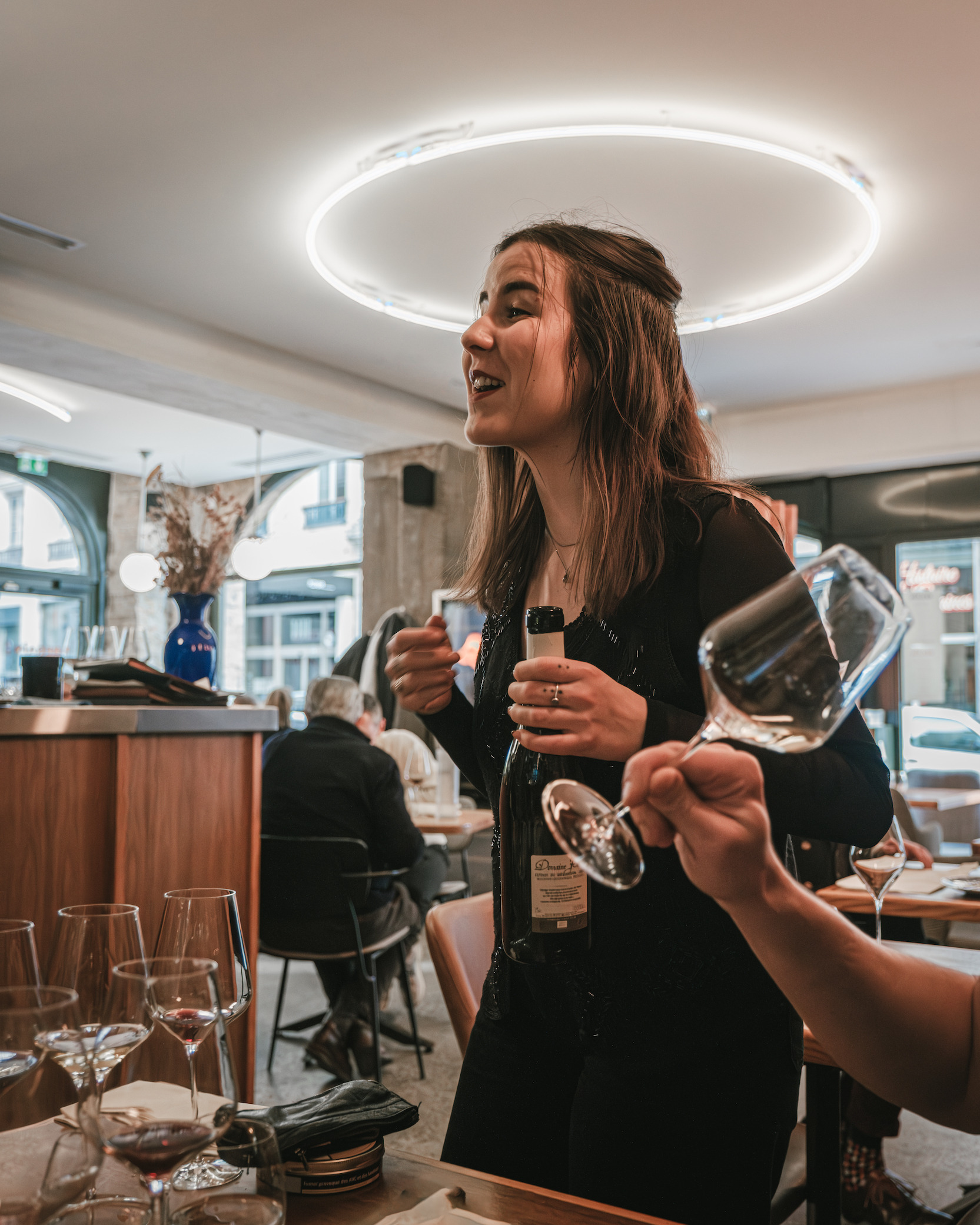 a woman is holding a wine glass in a restaurant