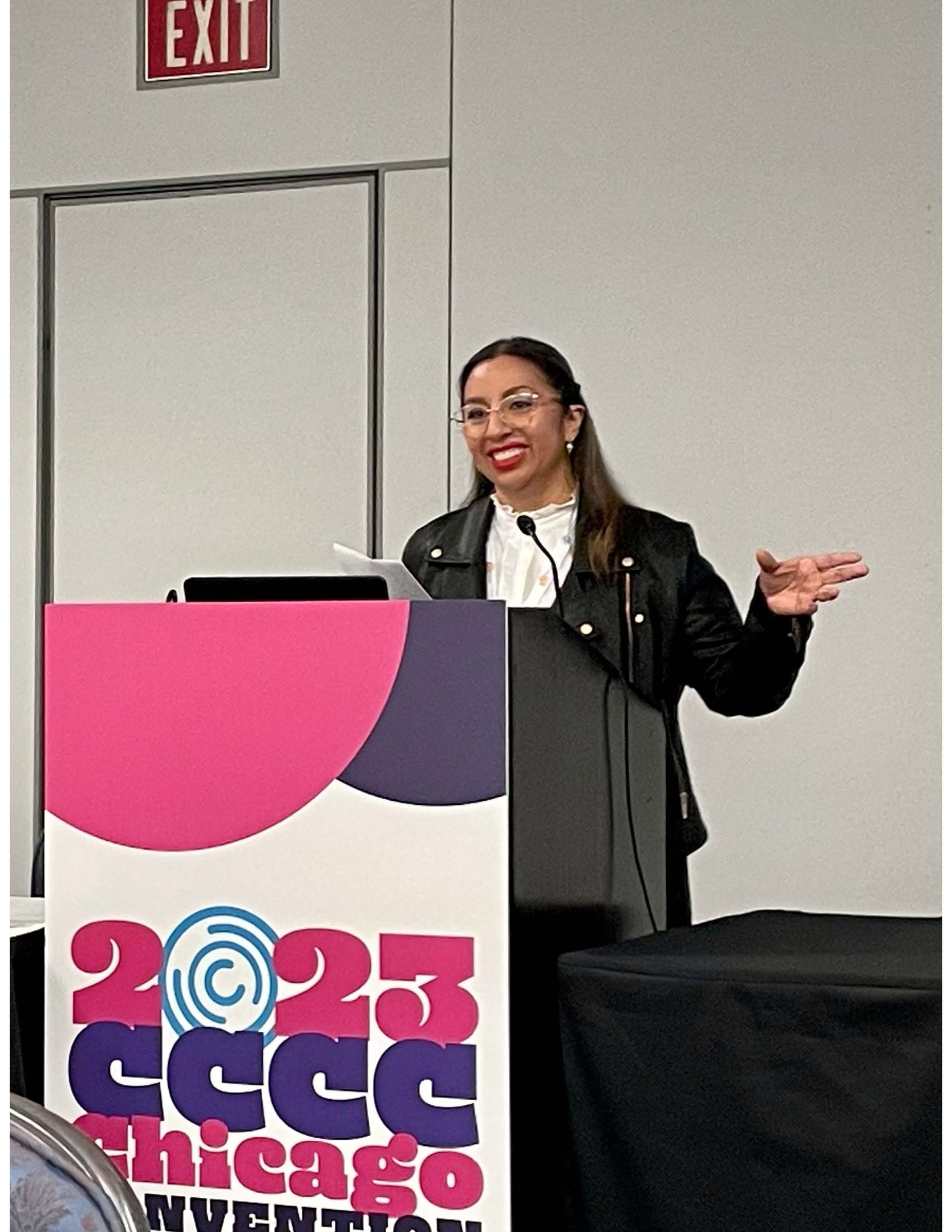 a woman standing at a podium with a microphone