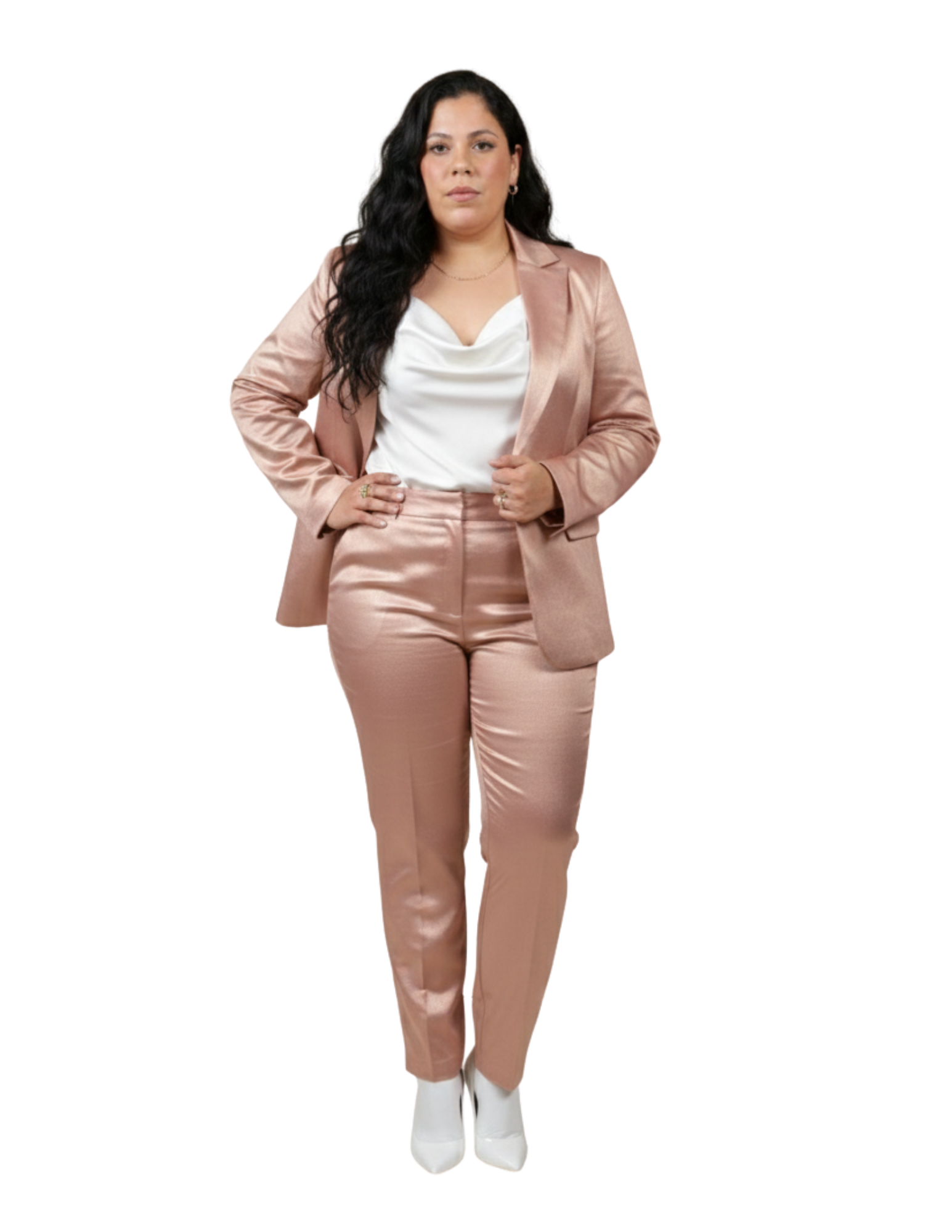 Professional woman in a shimmering rose gold satin blazer and trousers suit with a white cowl neck top.