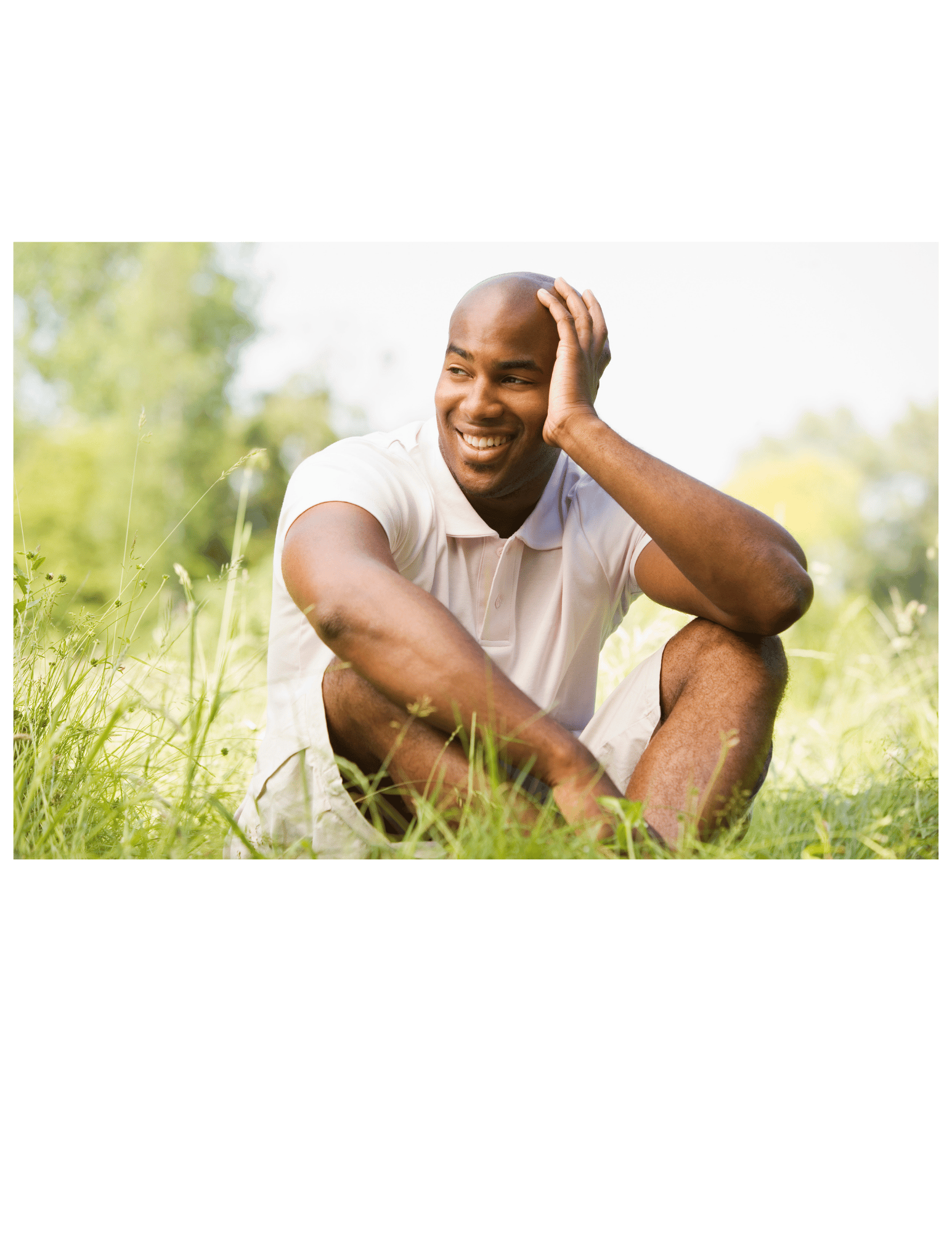Man sitting in grass enjoying the connection to the earth: Grounding