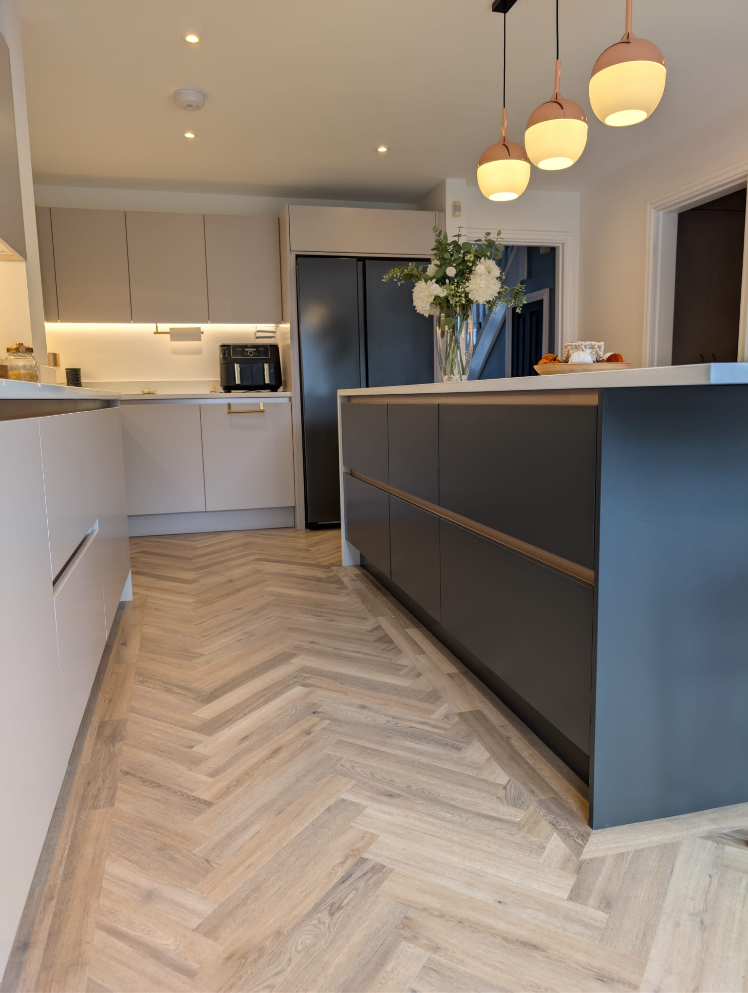 kitchen with airfrier, and a kitchen island with flowers ontop of it