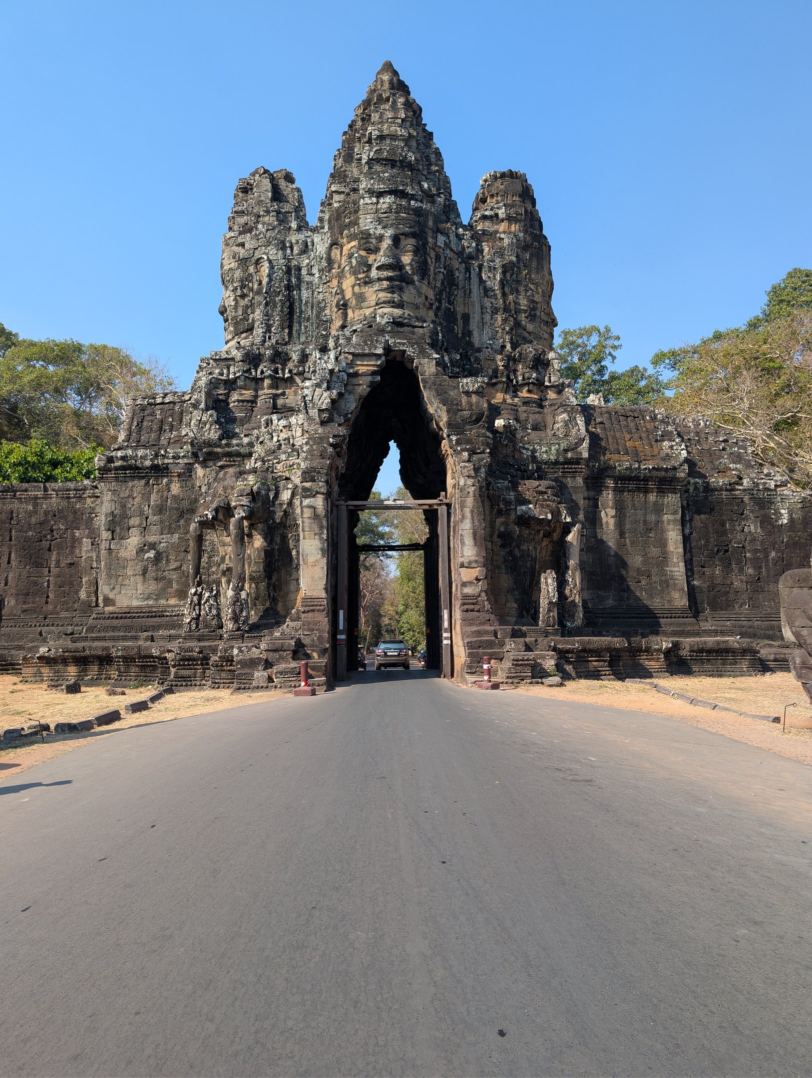 a road passing through a stone gate at Angkor Wat, Cambodia