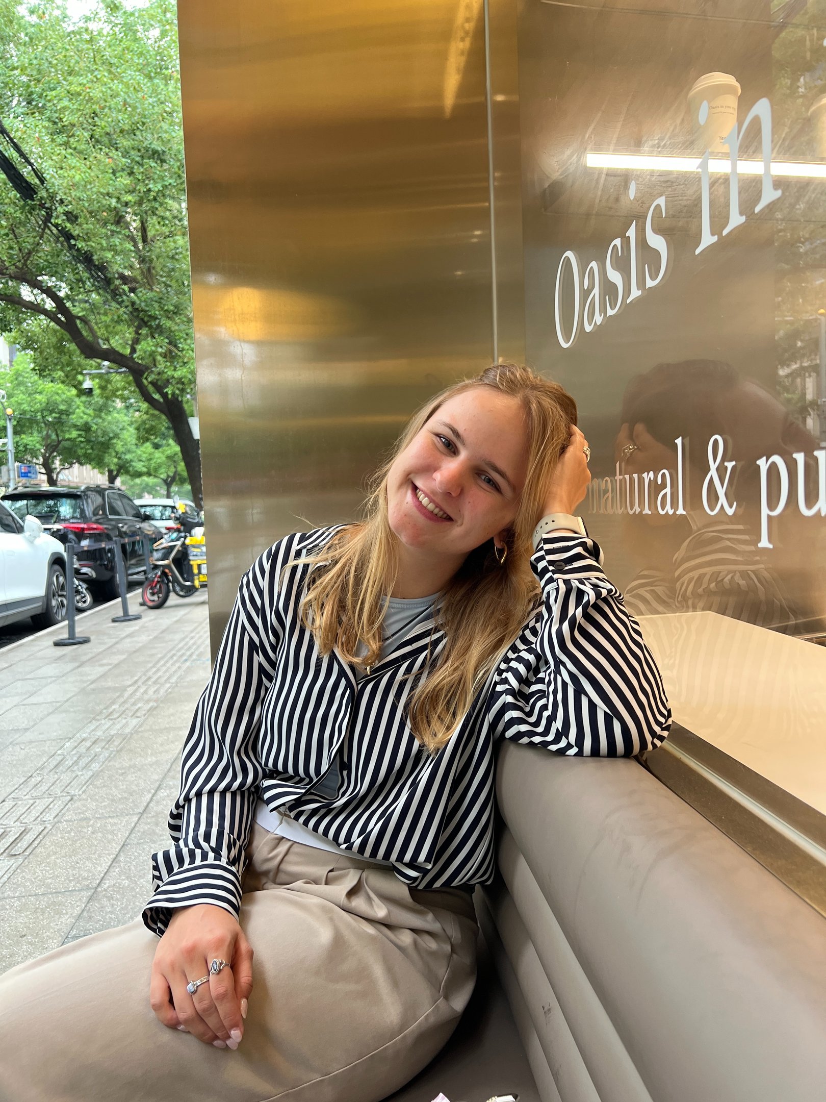 artist carina exner sitting on a bench smiling