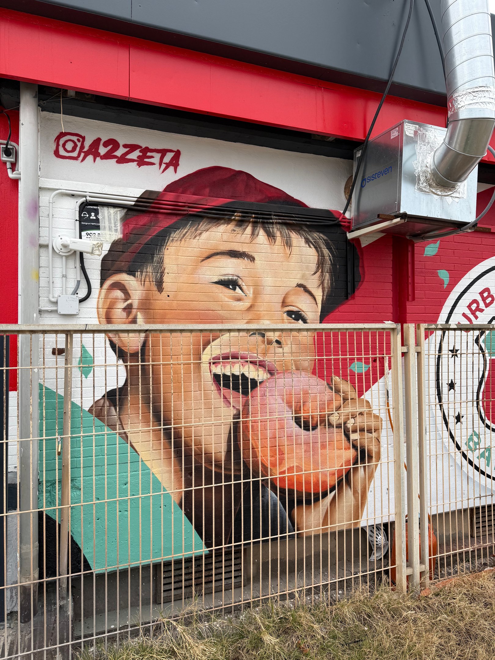 Mural de gran formato sobre fachada urbana realizado con aerosol. Representación figurativa que comb