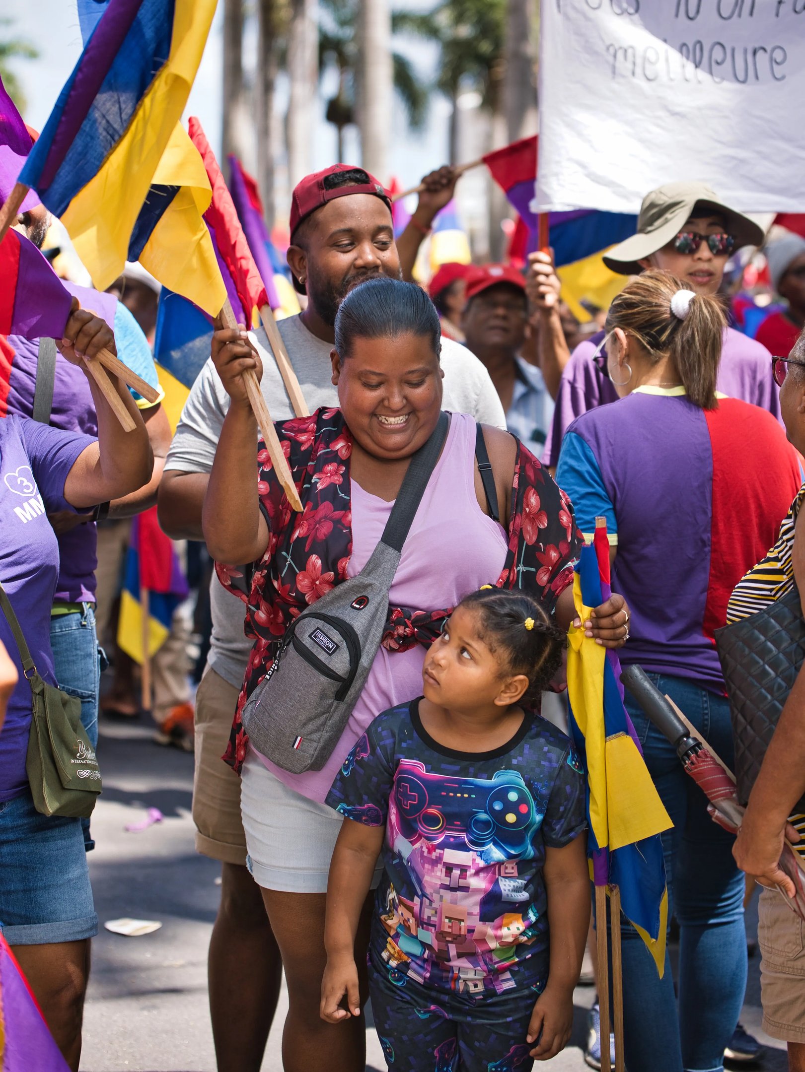 Smiling family in the crowd holding flags