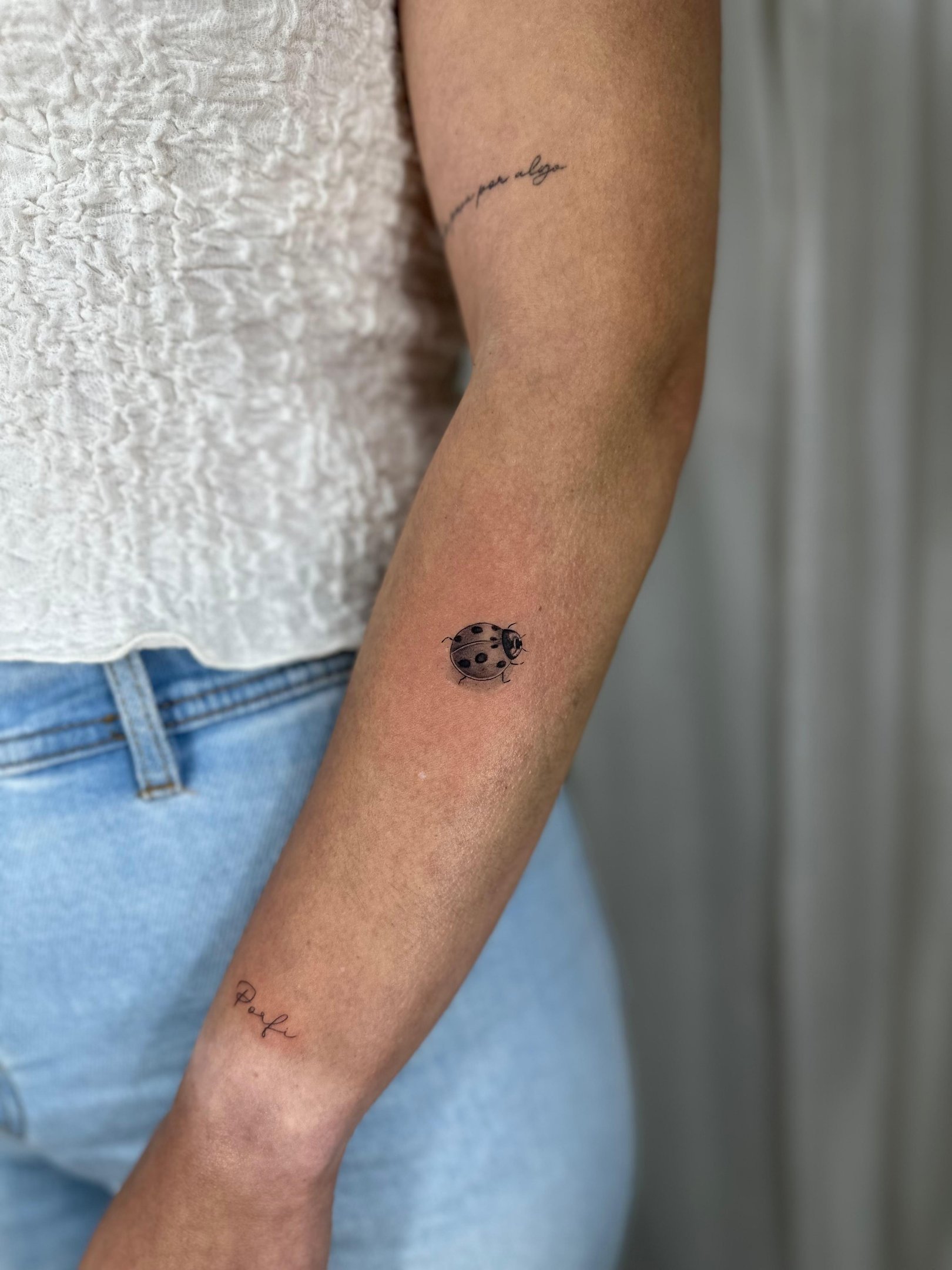 Tatuaje microrealismo en Madrid de mariquita con detalle realista en el antebrazo
