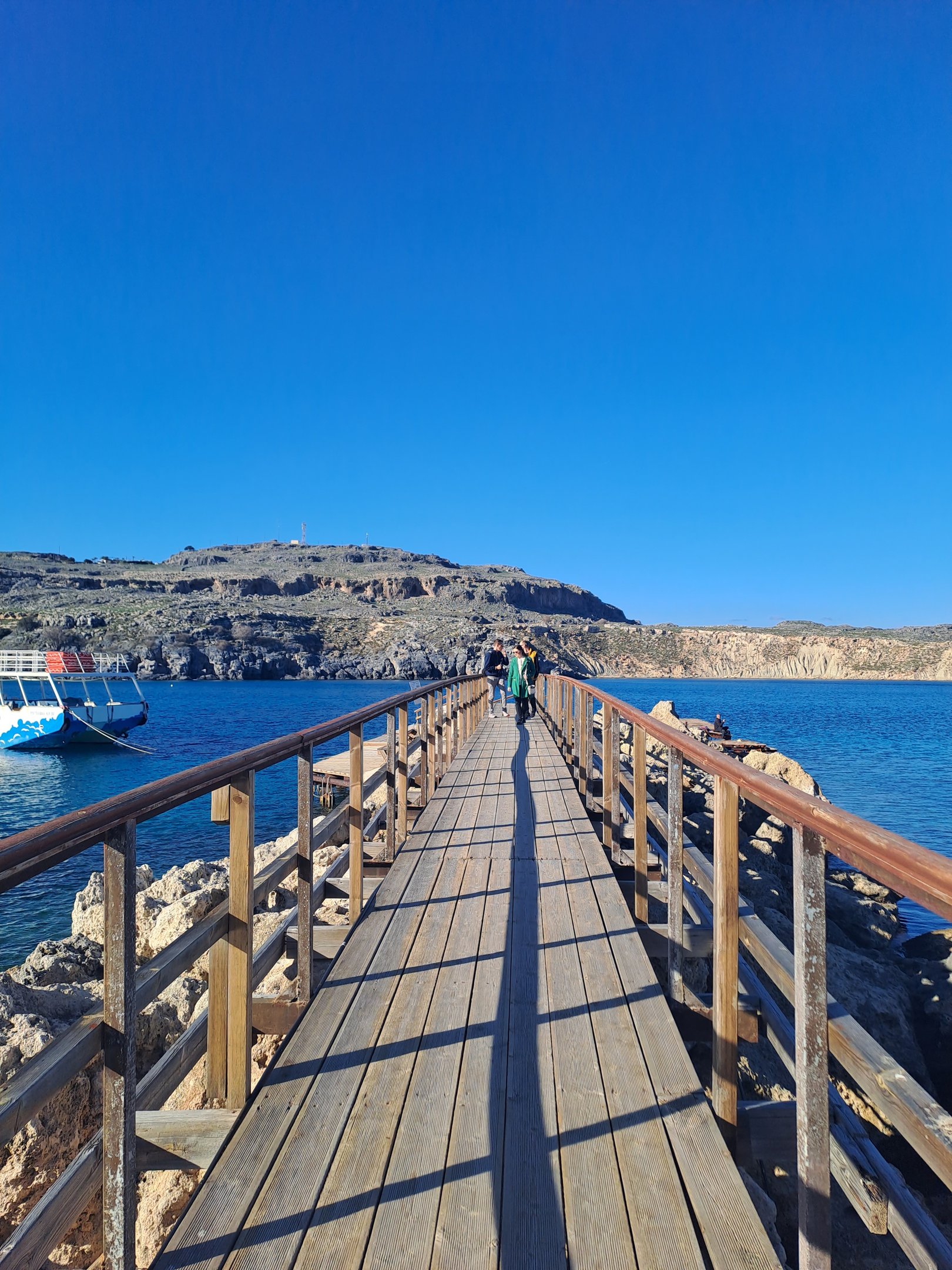 a wooden bridge with a boat in the water