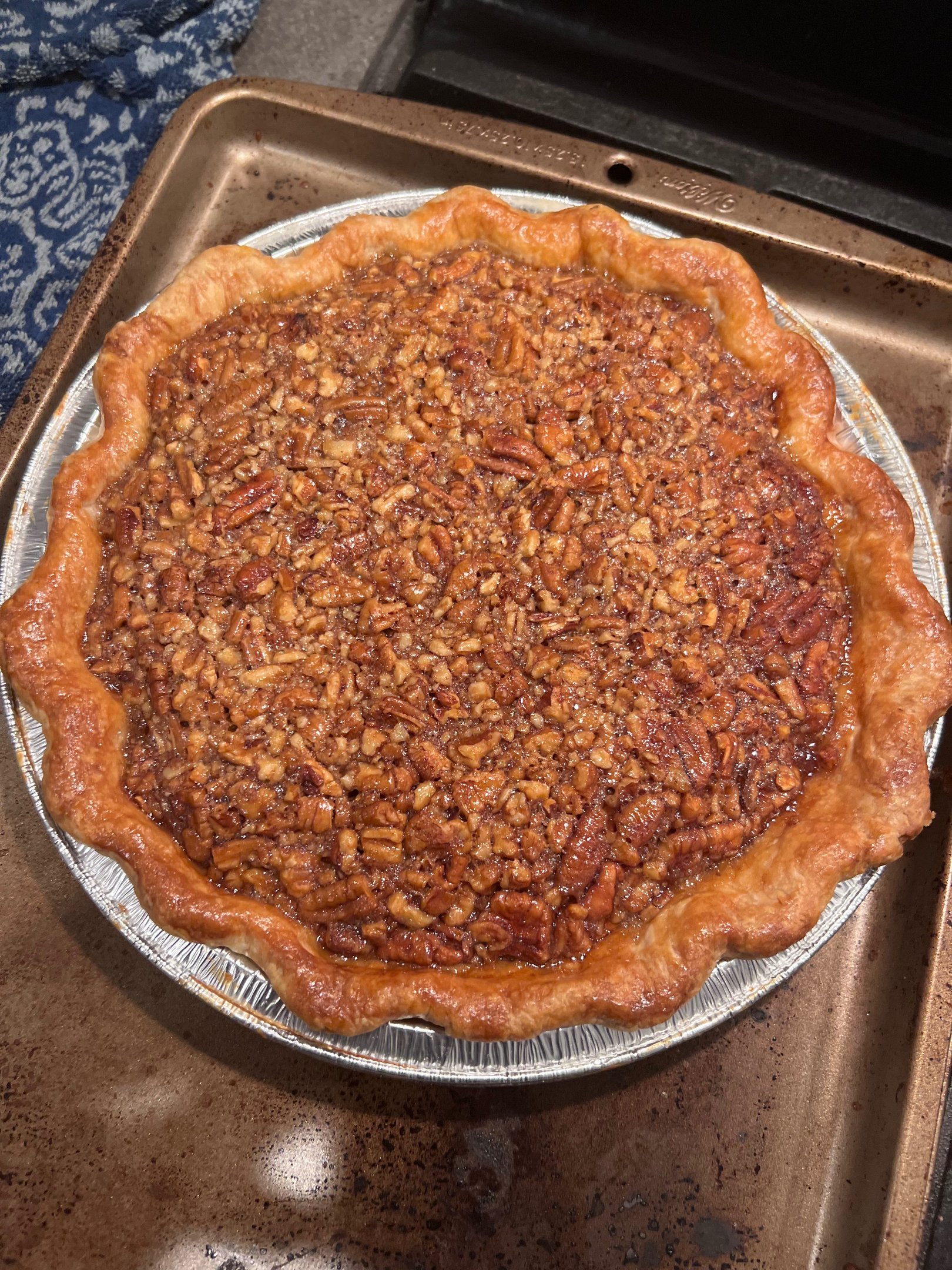 Freshly baked homemade pecan pie with a flaky golden brown crust and chopped nut filling.