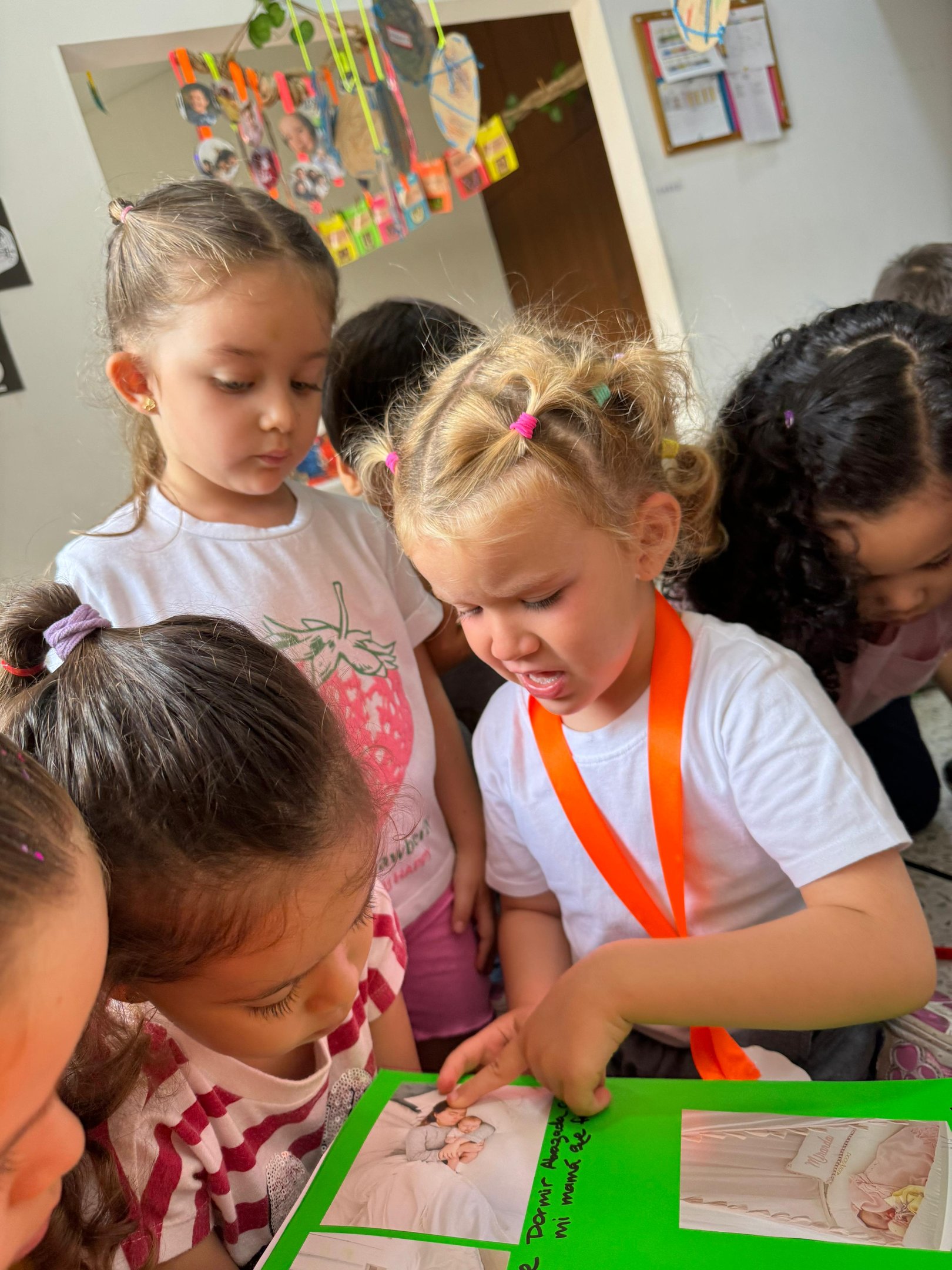 Niña mostrando a sus compañeros imagenes en jardín infantil Ukelele