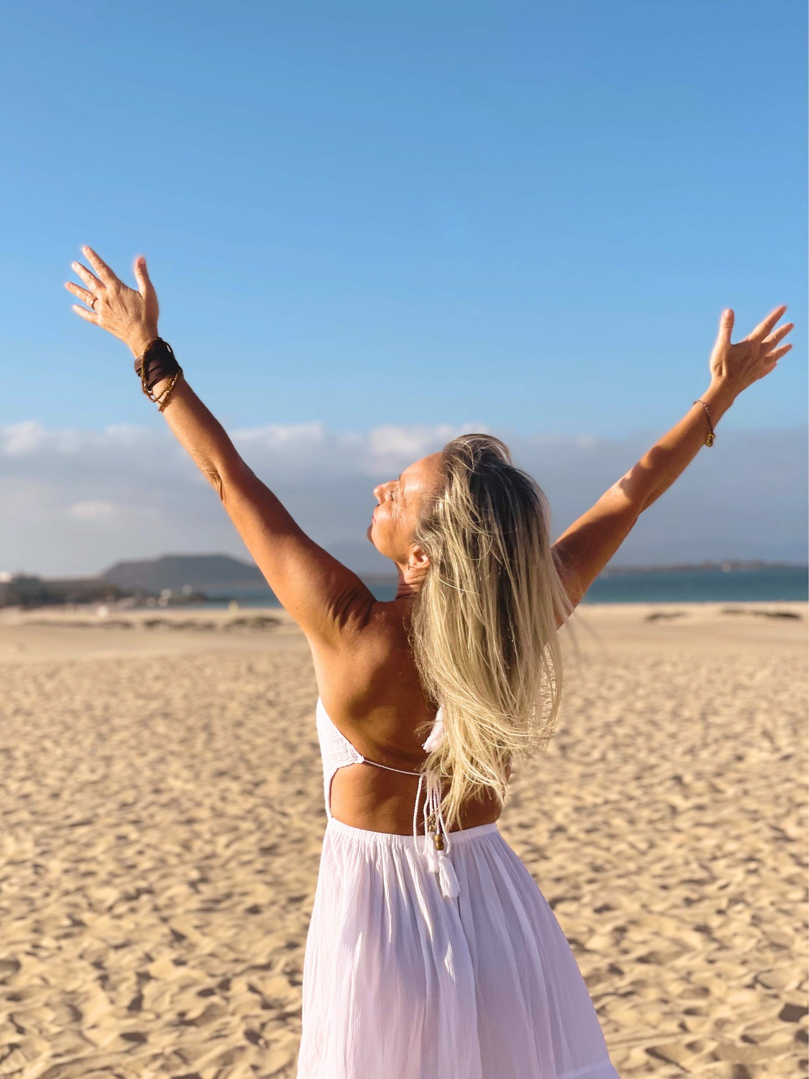 Valeria Angeletti, wellness coach di Metabolika, in abito bianco sulla spiaggia