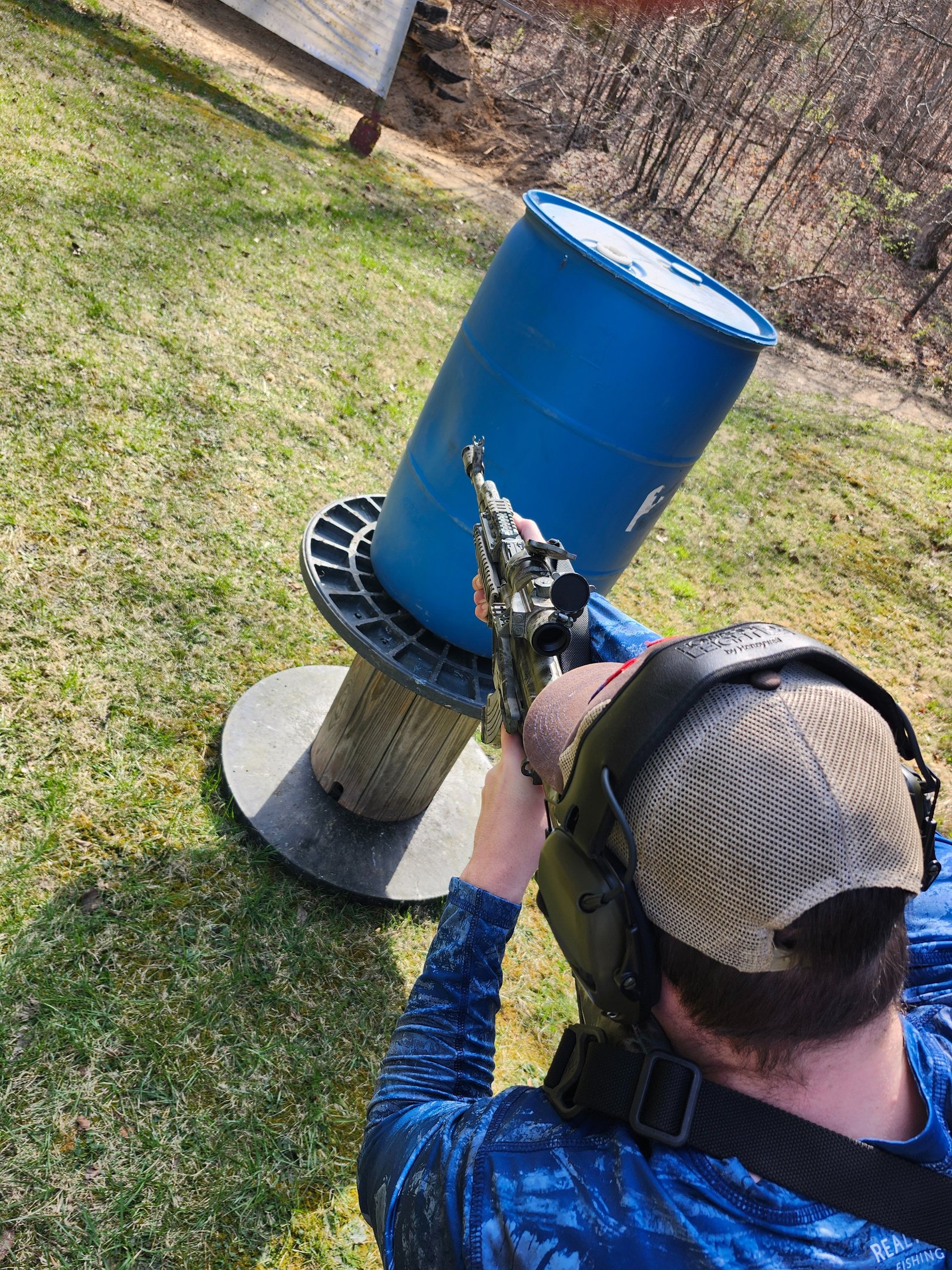 Man engaging targets from a barrier using self-defense firearm during training.