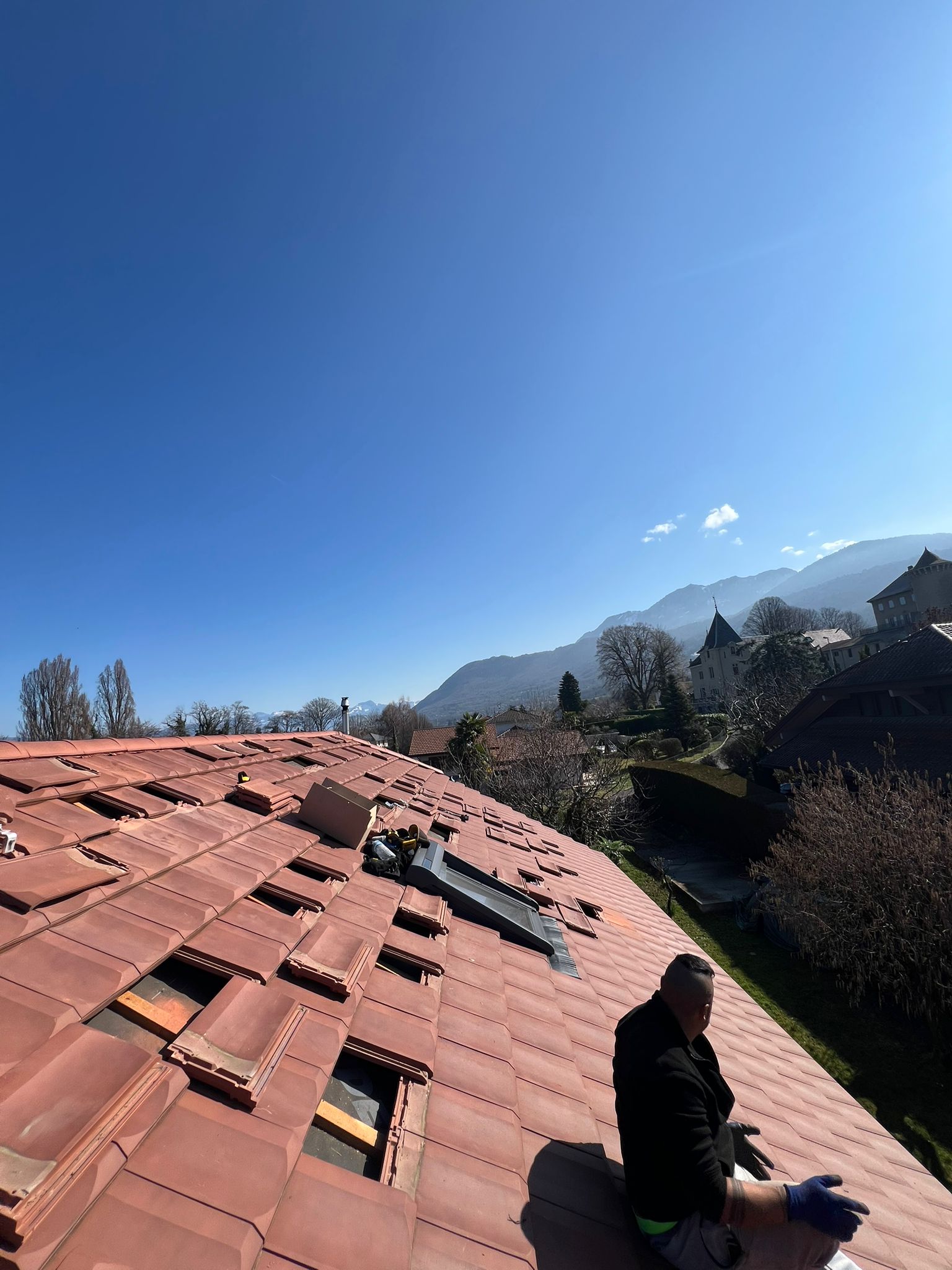 préparation de la toiture pentue autour d'un velux avant installation photovoltaïque de 9 kWc face au lac Léman